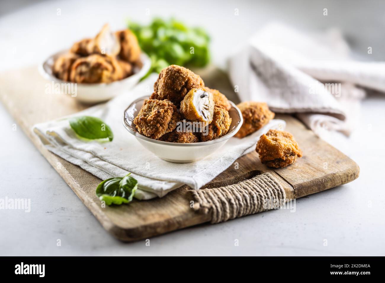 Fried mushrooms in breadcrumbs in a white bowl. Homemade crispy deep fried mushrooms. Stock Photo