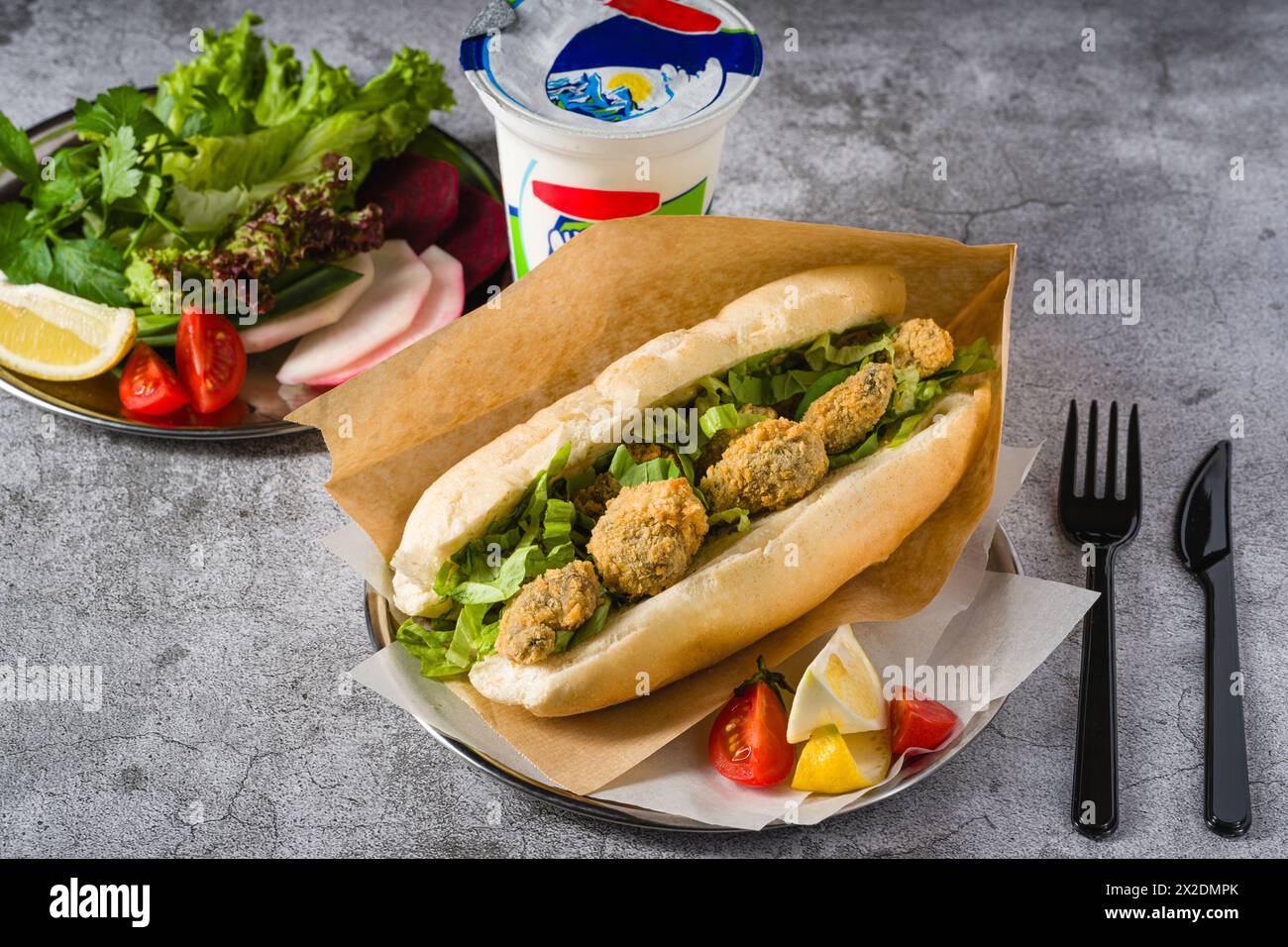Deep fried mussels in bread and with greens on the side. Turkish name Midye Tava Stock Photo