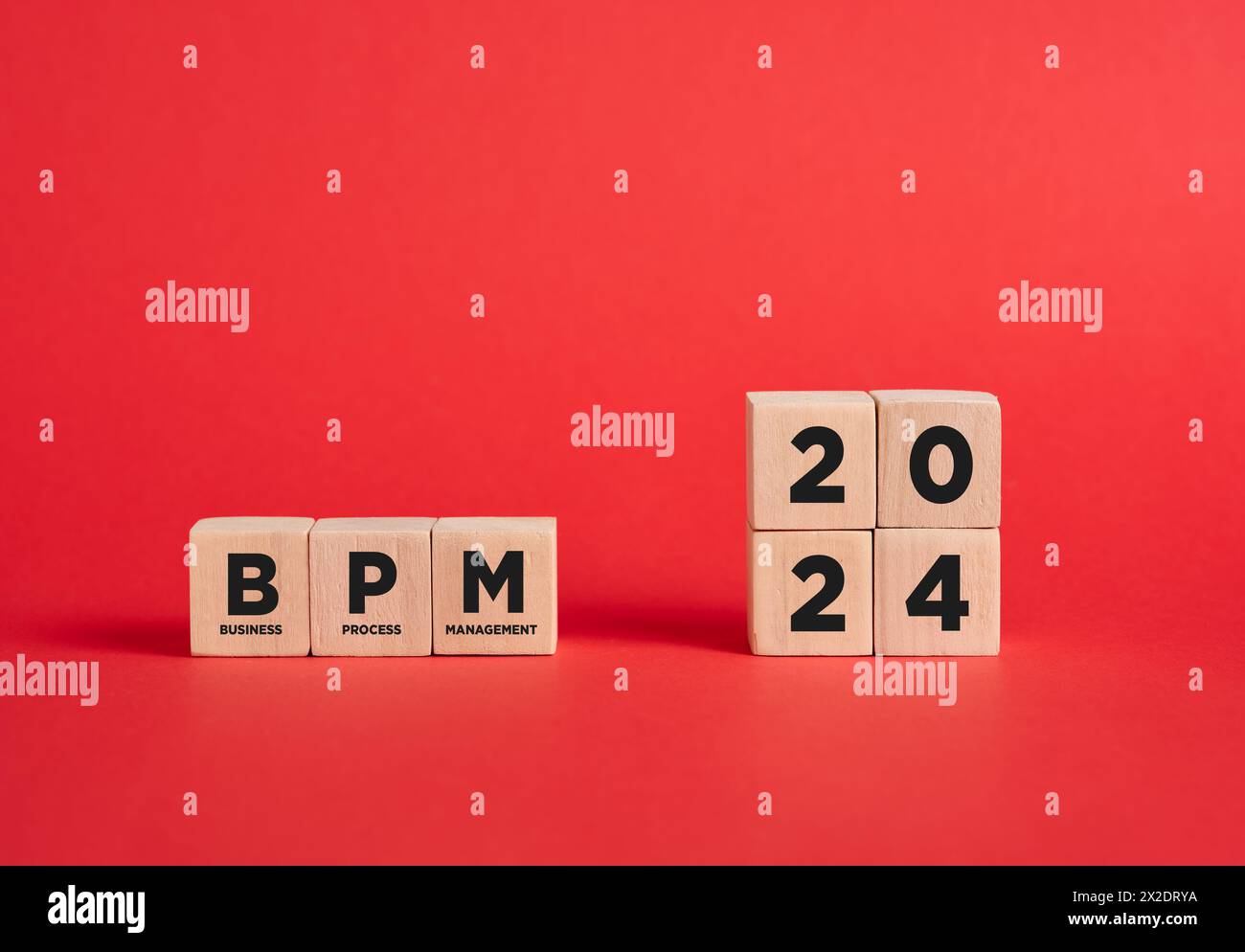 The abbreviation BPM business process management of the year 2024 on wooden cubes with red background. Stock Photo