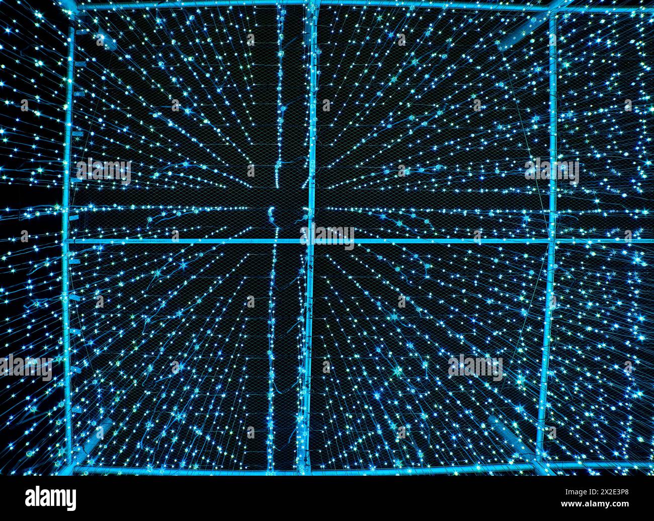 Rain of light blue drops of light falling off the sky at night. Artificial rainfall or precipitation made of lights resembles artificial intelligence Stock Photo