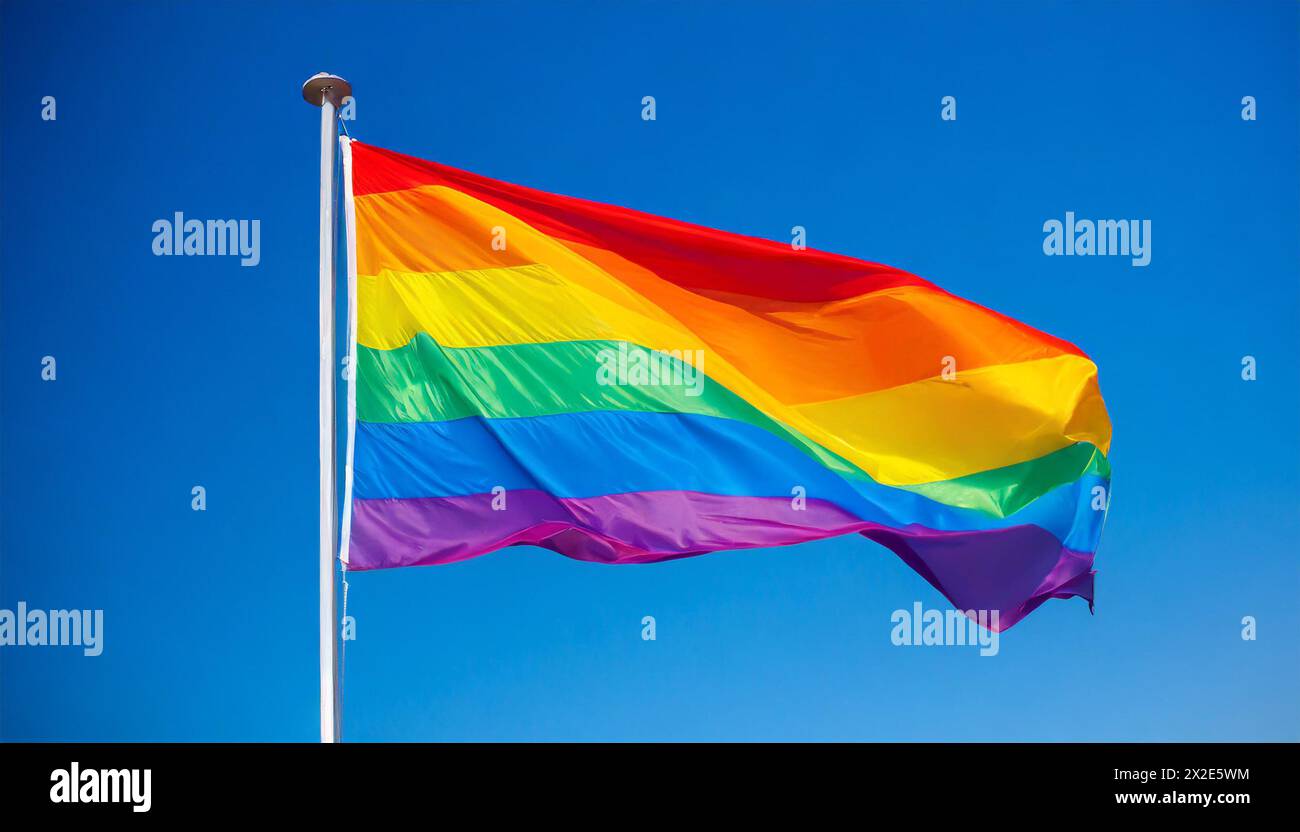 Die Regenbogenfahne flattert im Wind, isoliert, gegen den blauen Himmel, mit einer solchen Fahne wird in zahlreichen Kulturen weltweit die Stimmung fü Stock Photo