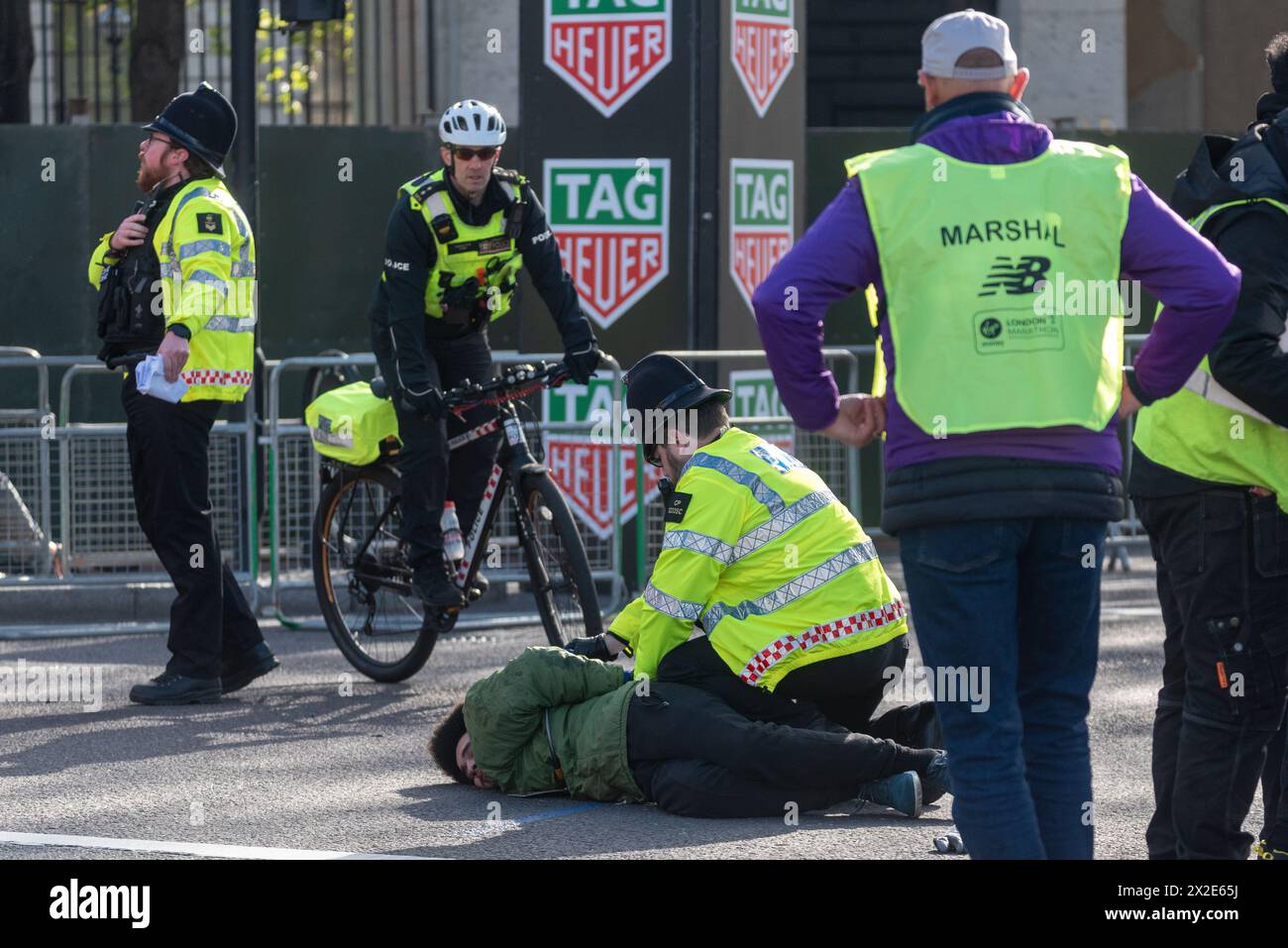 Police detained a male for forcing his way onto the closed road section of the route of the London Marathon, pushing his way past marshals Stock Photo