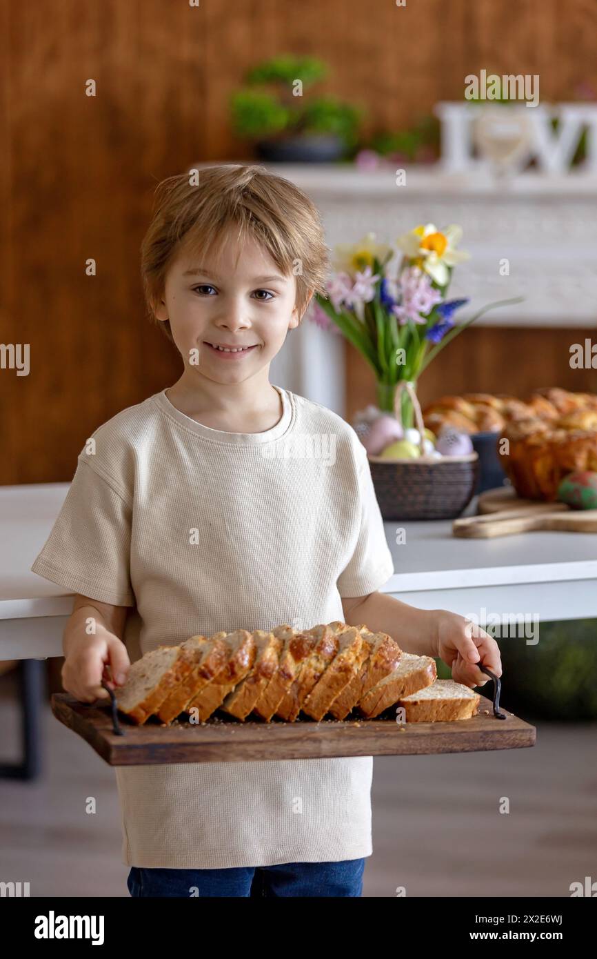 Cute preschool child, boy, holding sweet brioche bun for Easter ...