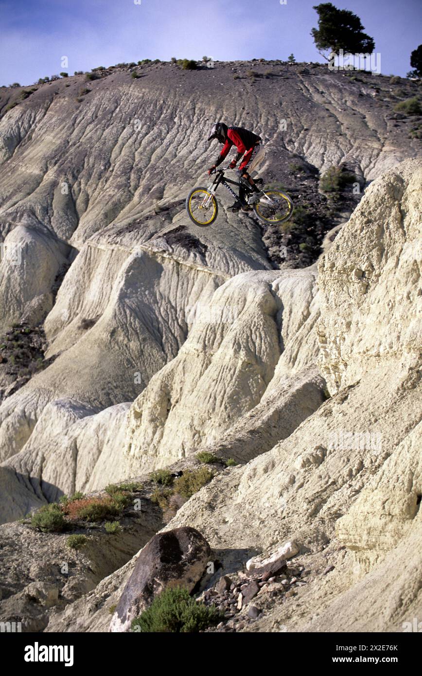 Man jumping off a big rock on his mountain bike in Richfield, Utah