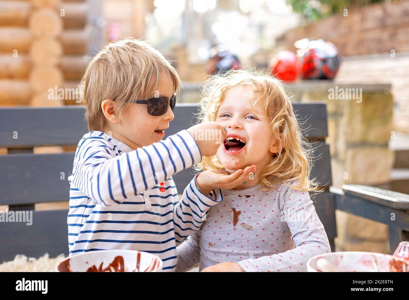 Children, kids, siblings, eating chocolate ice cream spring time, outdoors Stock Photo