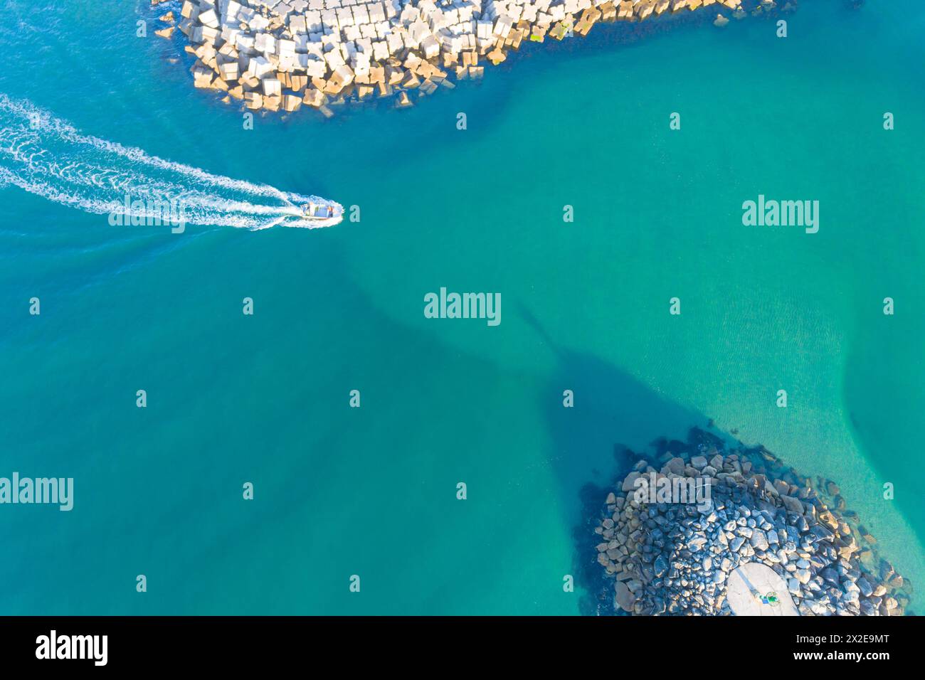 Aerial top view with drone of a fishing boat entering a harbor Stock Photo