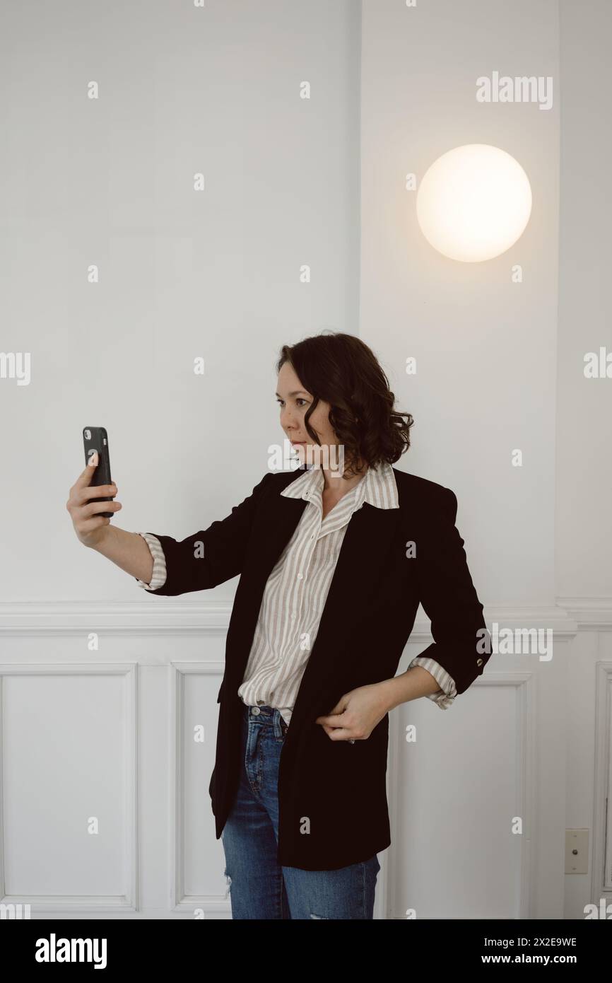 Business woman holds phone while on a video call meeting Stock Photo