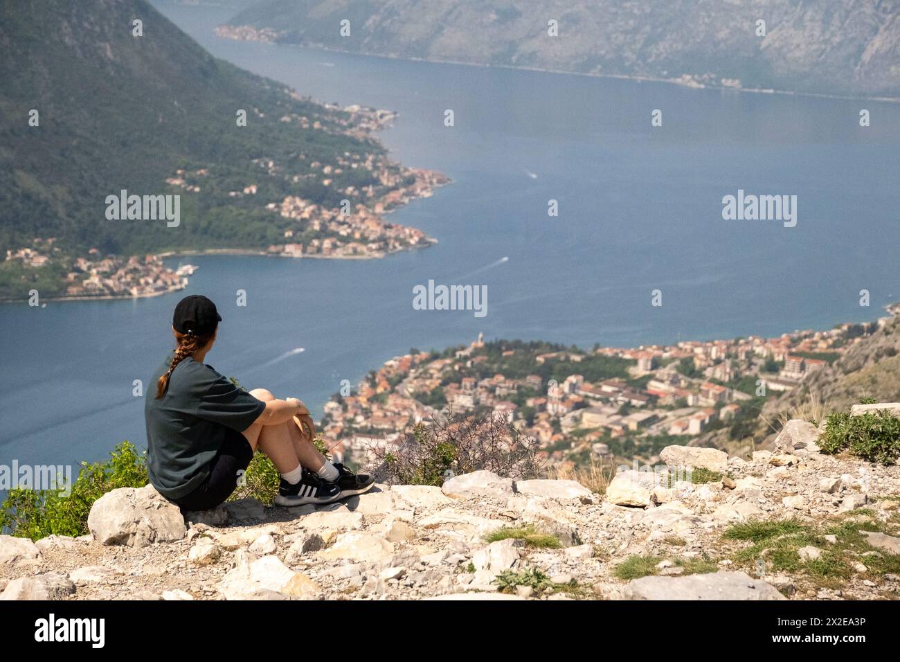 Woman sat on the top of mountain in Kotor Bay Stock Photo
