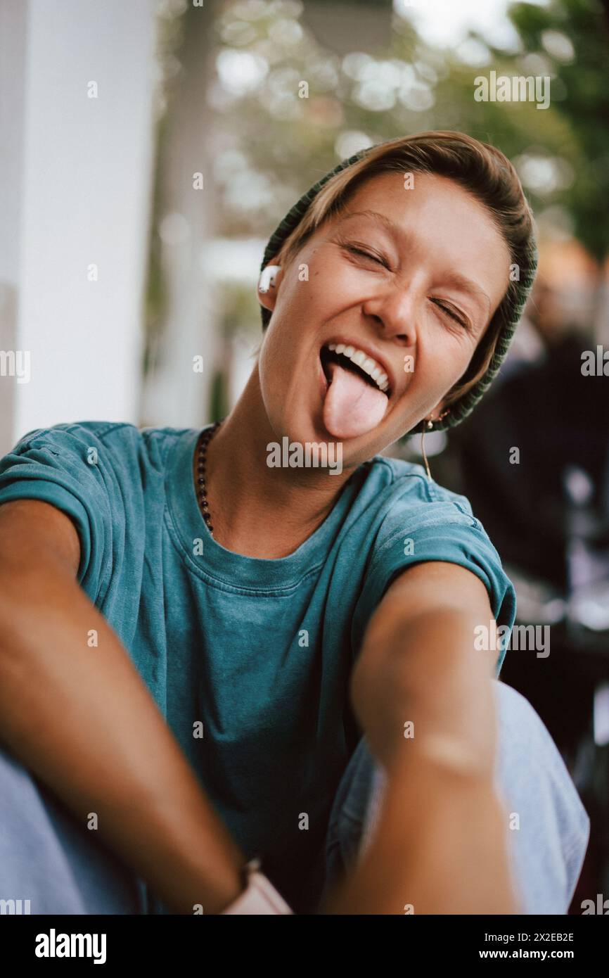 Emotional portrait, young woman, tongue hanging out. Stock Photo