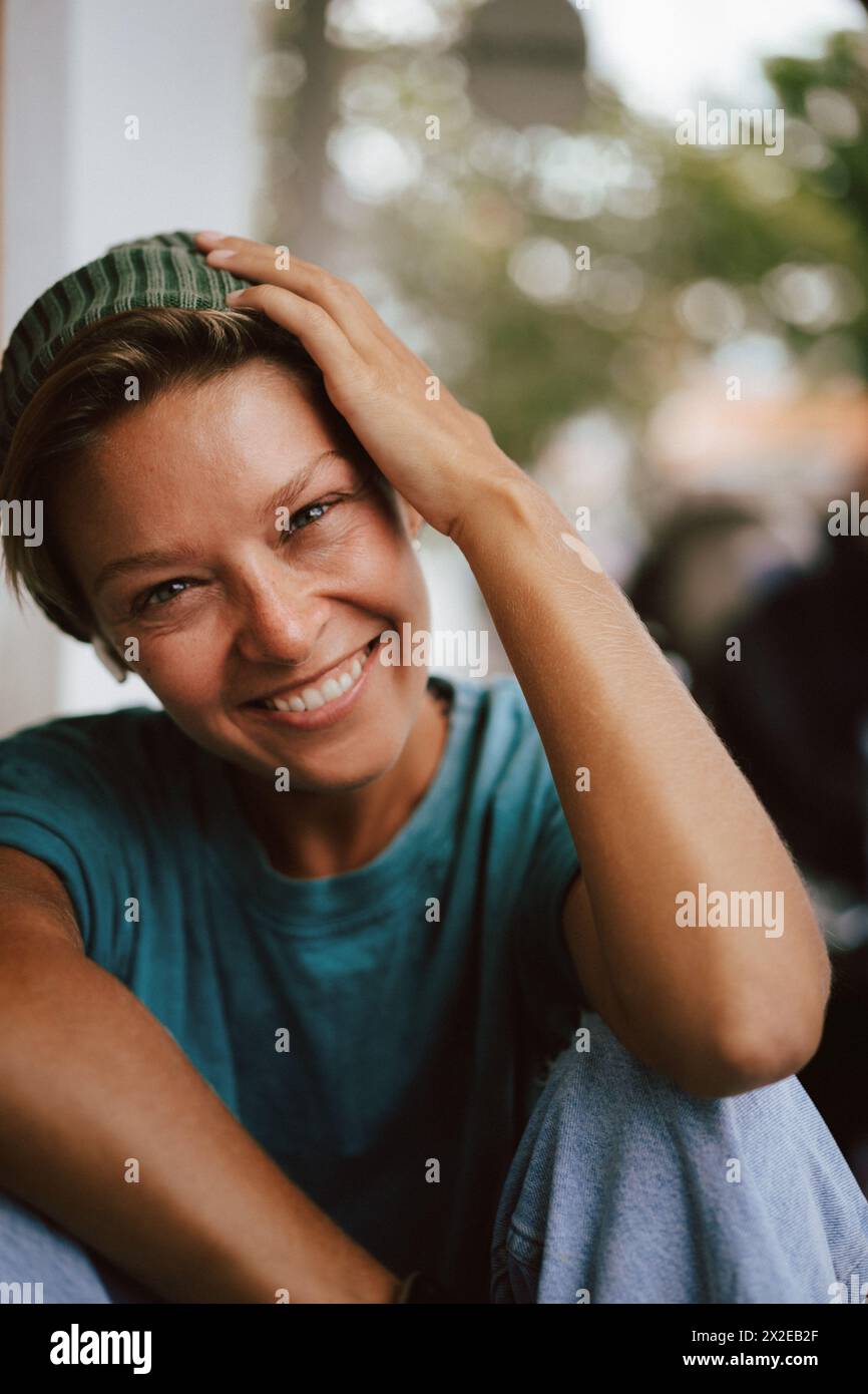 Happy laughing woman pulling her cap over her eyes. Fool. Stock Photo
