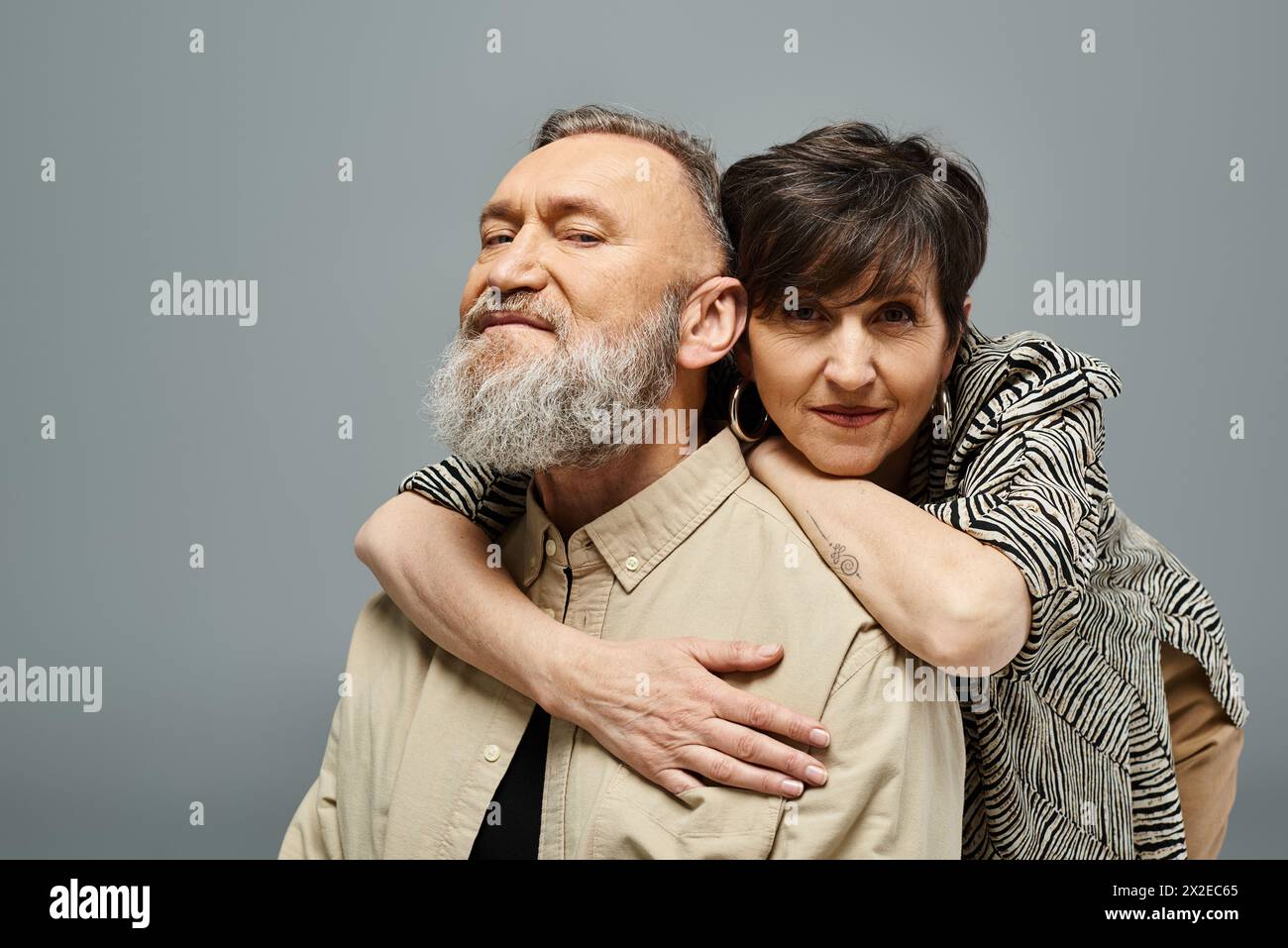 A Middle aged Man With A Beard Tenderly Hugs A Woman In Stylish Attire a-middle-aged-man-with-a-beard-tenderly-hugs-a-woman-in-stylish-attire