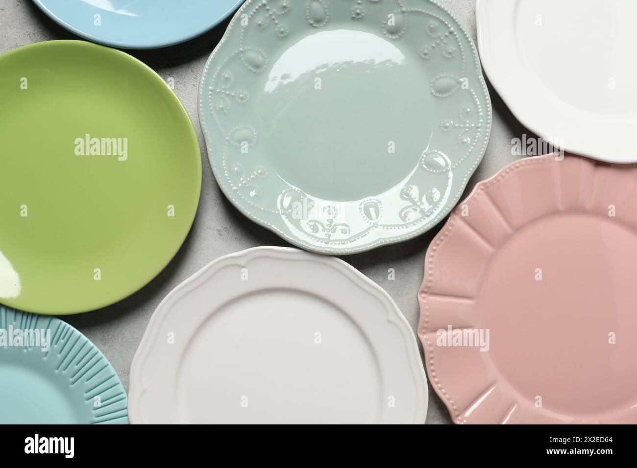 Beautiful ceramic plates on light grey table, flat lay Stock Photo