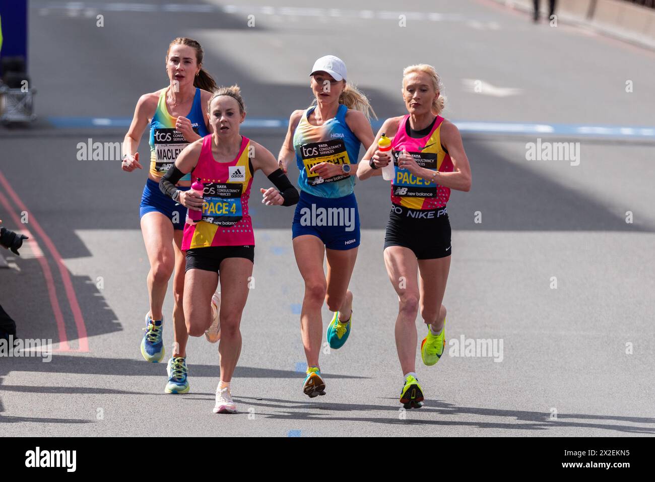 Mhairi MacLennan and Alice Wright competing in the TCS London Marathon 2024 passing through Tower Hill, London, UK. Purdue & Thackery pace runners Stock Photo