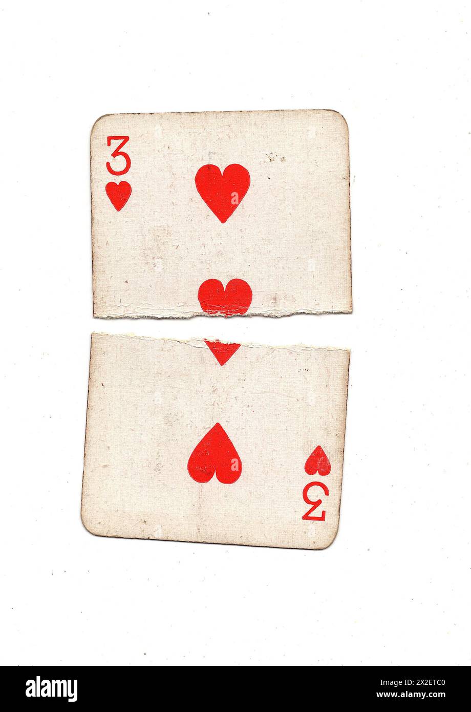 A vintage, well used three of hearts playing card torn in half on a ...