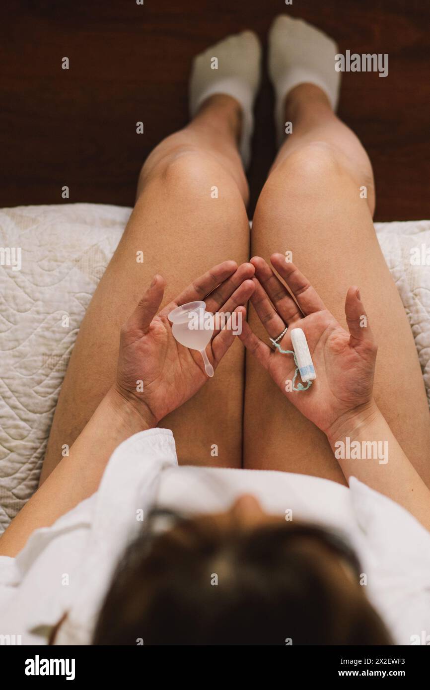 Woman holding tampon and menstrual cup Stock Photo