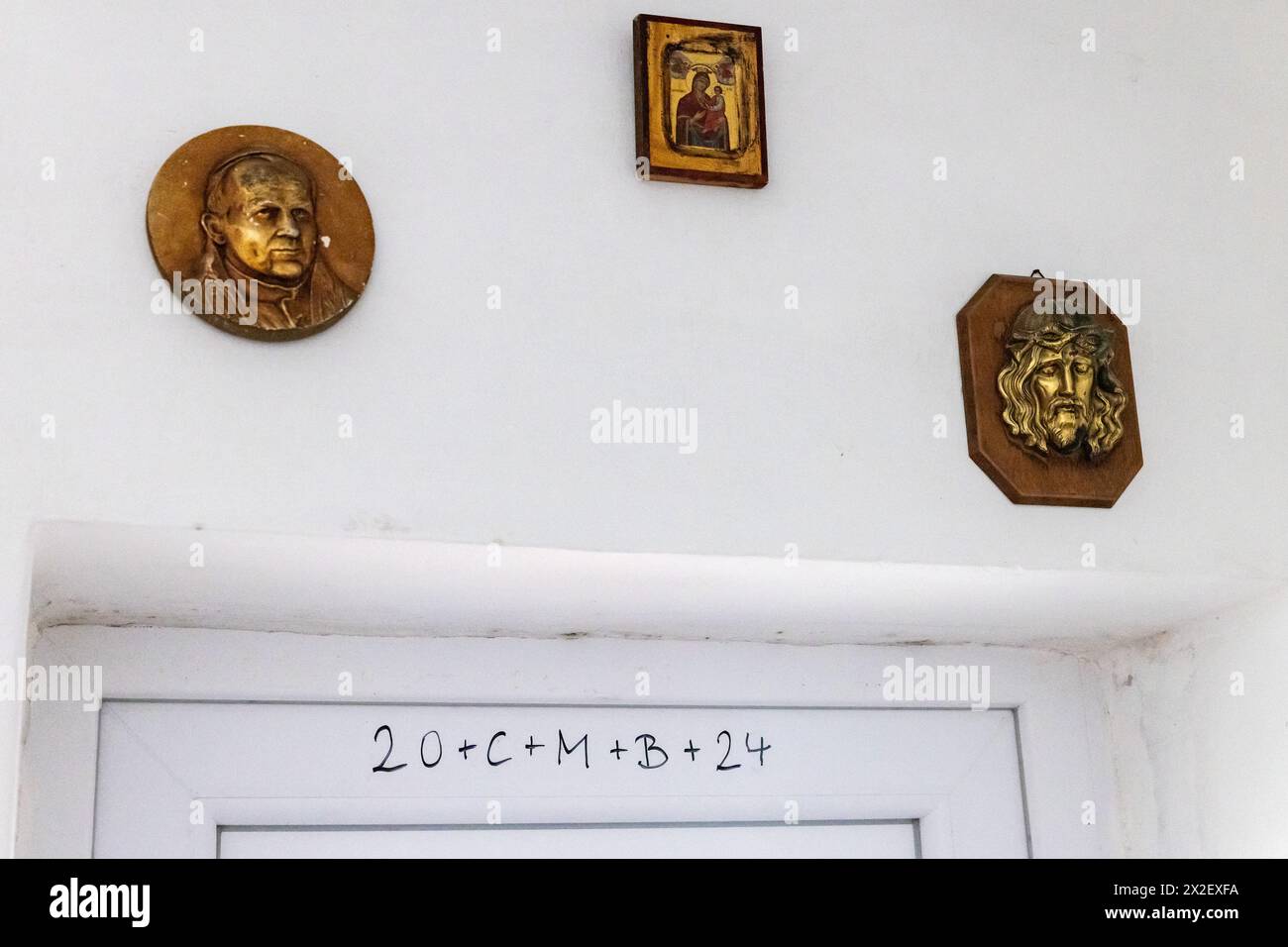 Szephalom, Hungary. 30th March, 2024. Religious icons appear above a door on which is handwritten the date on which a priest last visited to bless the household. Credit: Mark Kerrison/Alamy Live News Stock Photo