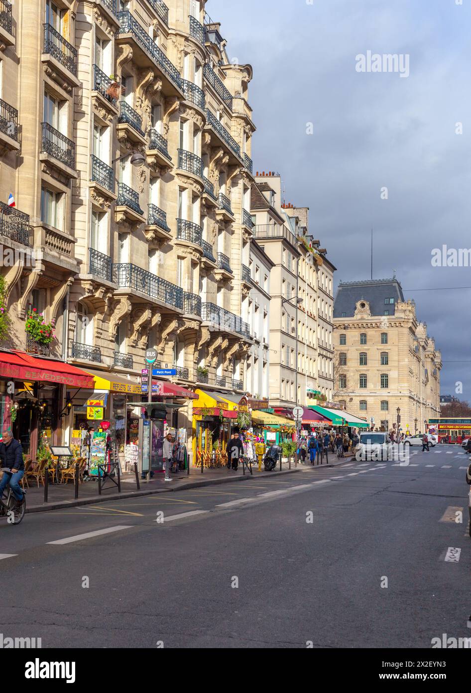 Bustling Parisian street life with classic architecture and sidewalk cafes. Stock Photo