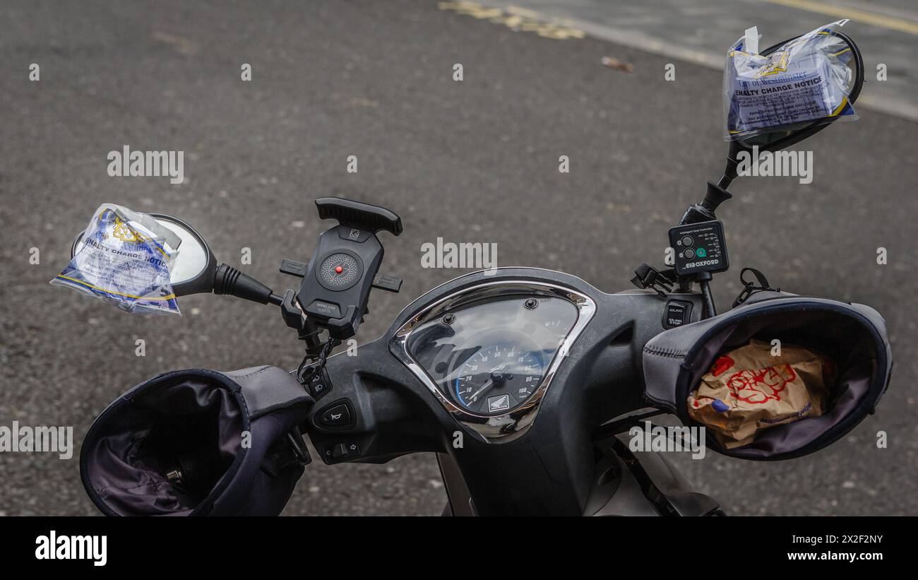 A motorbike with two penalty notice tickets on a street in London. Stock Photo