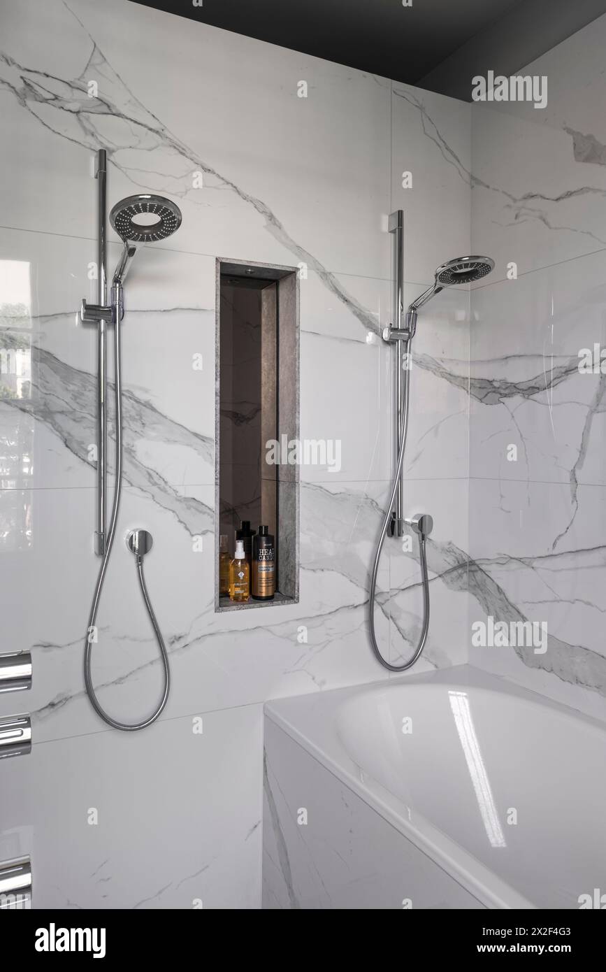 Twin shower fittings in simple, modern marble bathroom in Georgian townhouse. Paultons Square, Chelsea, London, UK. Stock Photo