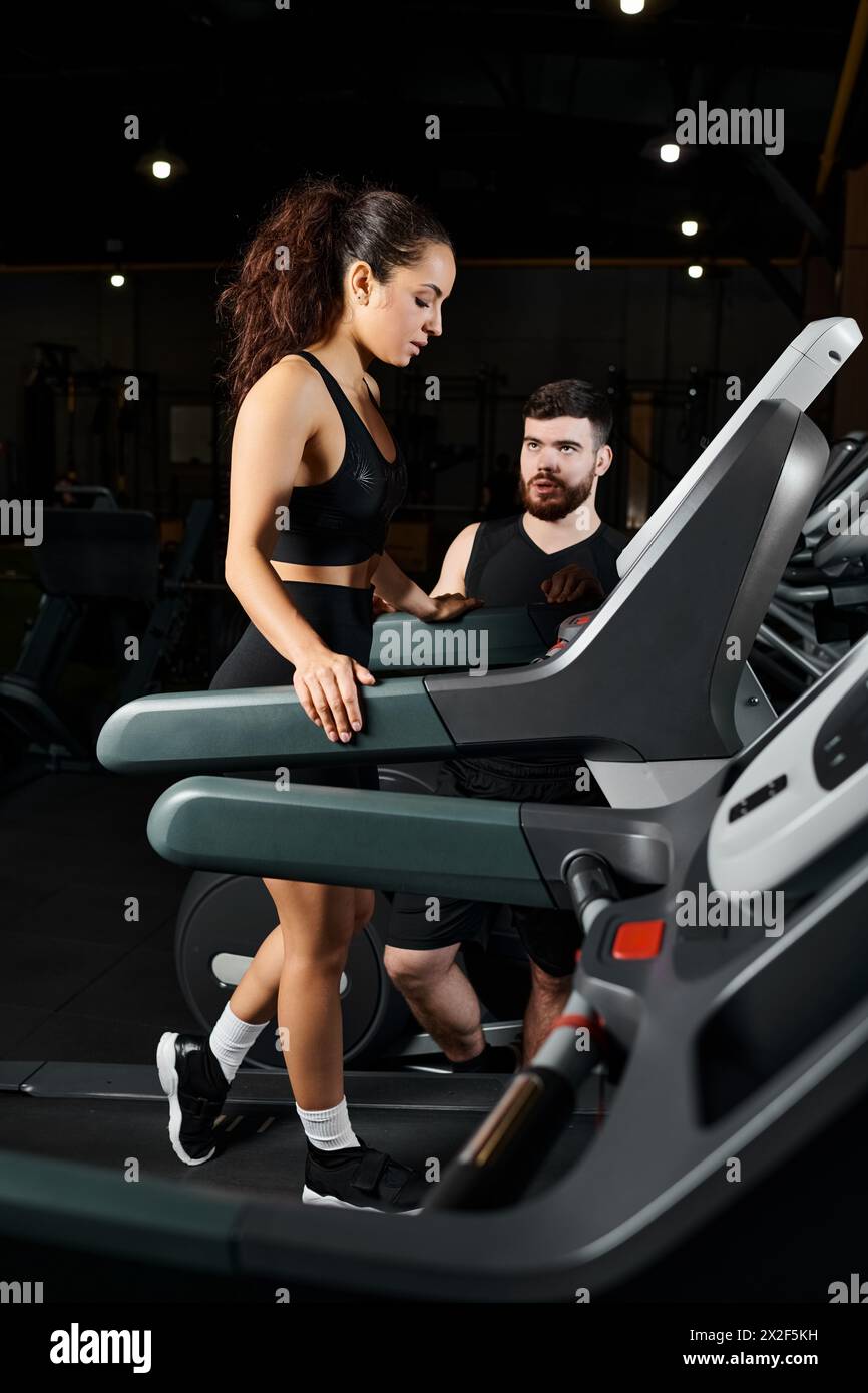 A male personal trainer and a brunette sportswoman are energetically running on a treadmill in a gym Stock Photo Alamy