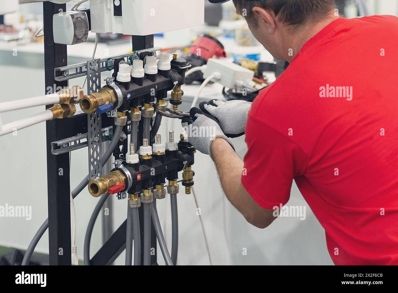 Installing collector for warm water underfloor heating system. Plumber work. Stock Photo