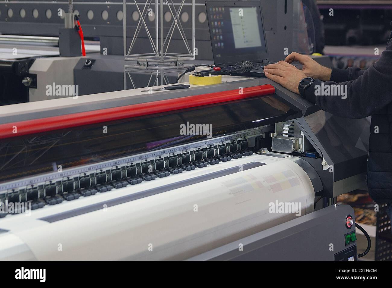 A man adjusts the printing process on a large format printing machine. Industry Stock Photo