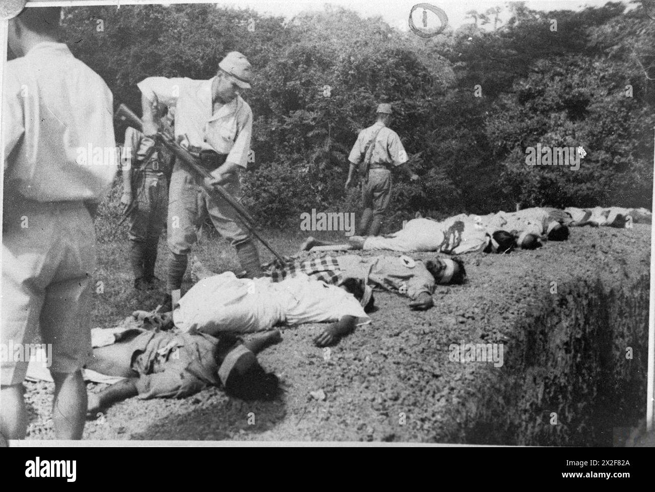 ATROCITIES CARRIED OUT BY JAPANESE FORCES DURING THE SECOND WORLD WAR - Japanese soldier bayonetting one of the executed Sikh prisoners , Stock Photo