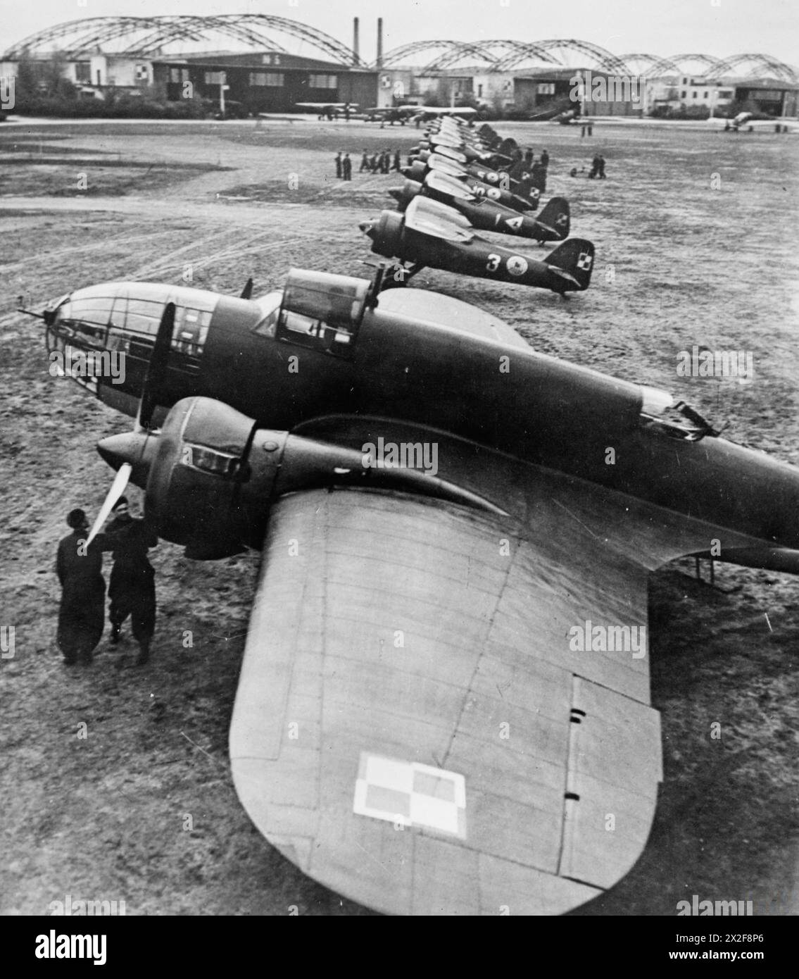 THE POLISH AIR FORCE IN THE INTERWAR PERIOD - A PZL.37 'Łoś' medium bomber of the 1st Air Regiment with a row of PZL P.11 fighter planes of the 111th and 112th Fighter Escadrilles in the background. Okęcie airfield near Warsaw, early 1939 Polish Air Force, Polish Air Force, 303 'Kościuszko' Fighter Squadron, Polish Air Force, 315 'City of Dęblin' Fighter Squadron Stock Photo