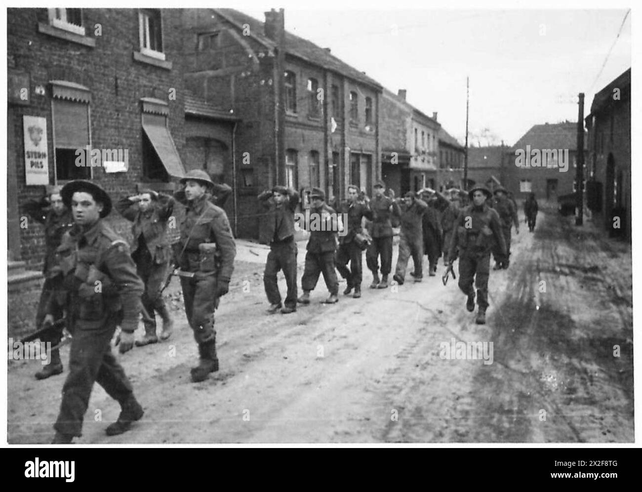 British troops march German prisoners through a captured village in ...