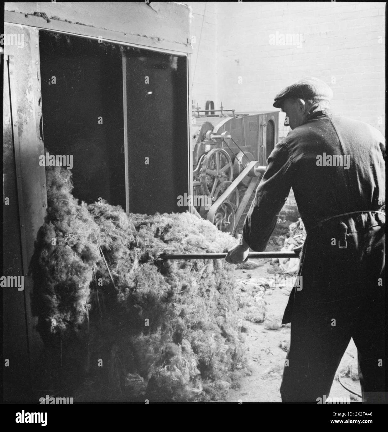A textile worker in Britain in April 1942 processes shoddy from rags ...