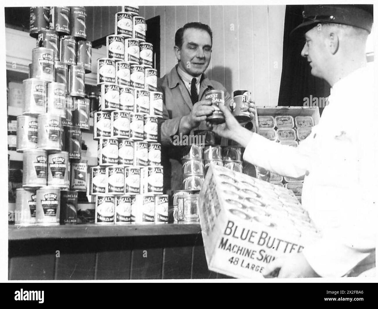 SARDINE TINS TO TANKS - NAAFI Grocer's shop in Limitary Camp issuing tin stores to Sergeant Cook British Army Stock Photo