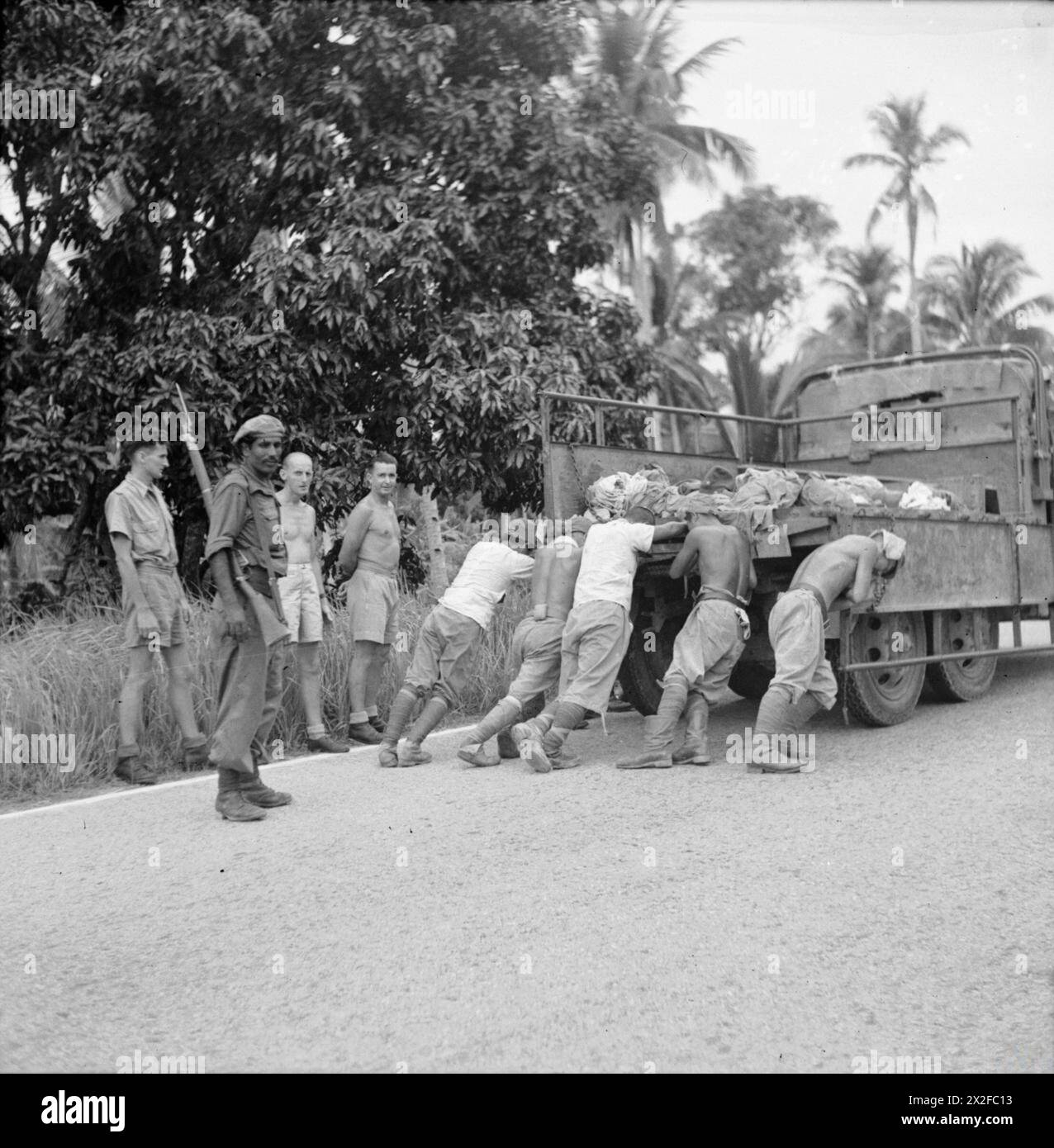 THE BRITISH ARMY IN THE FAR EAST 1945 - Released British POWs watch as ...