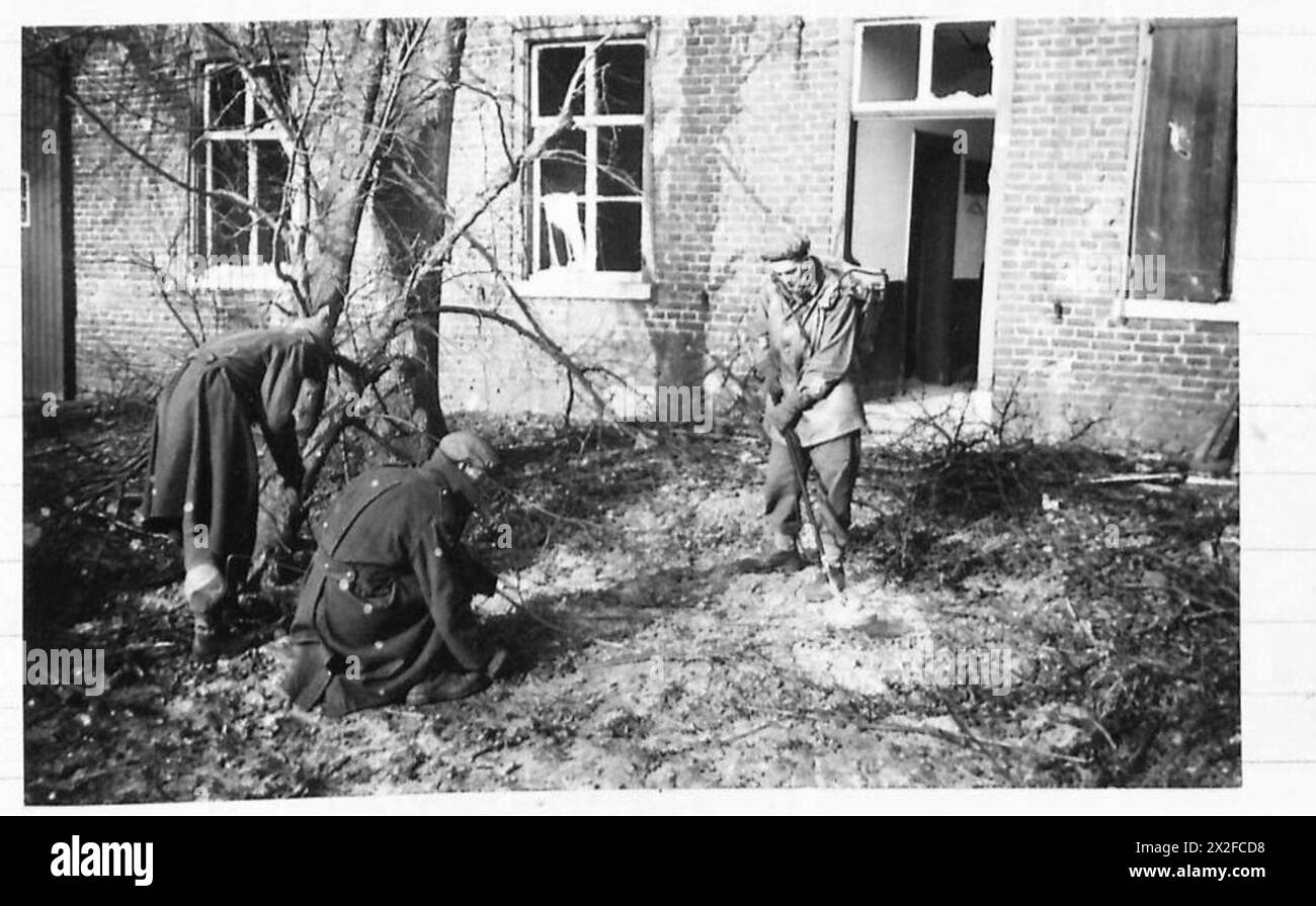 THE BRITISH ARMY IN NORTH-WEST EUROPE, 1944-1945 - Three soldiers of the 20th Field Company RE search for mines at Meijel using a No 3 Polish Mine Detector. The village of Meijel in Holland was found heavily mined and booby trapped. The pictures show the No 3 Polish Mine Detector, prodders and a new method of compressed air used to detect mines.The compressed air method, stated to be introduced by Lieutenant W. Campbell, of the 20th Field Company, Royal Engineers, 227th Brigade, 15th Scots Division, was in use for the first time and during its first trial 92 teller mines and several Shoe (Wood Stock Photo