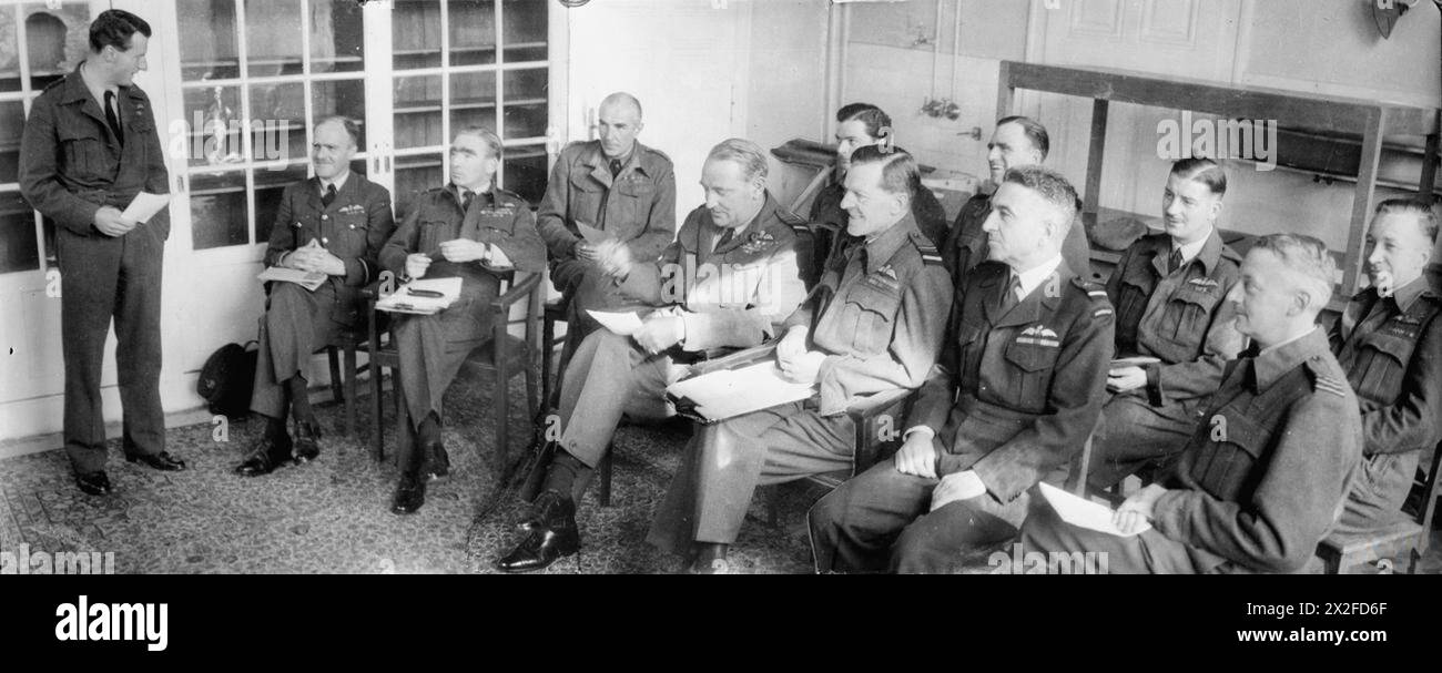 ROYAL AIR FORCE: 2ND TACTICAL AIR FORCE, 1943-1945. - The Air Officer Commanding-in-Chief of 2nd TAF, Air Marshal Sir Arthur Coningham, holding his daily morning conference with his staff at 2nd TAF Headquarters, Suchteln, Germany. Standing at left, and addressing the conference, is Group Captain T F D Morgan, Group Captain Operations. Seated in the front row (right to left) are: Air Commodore A Geddes, Air Commodore Plans; Air Vice-Marshal T W Elmhirst, Air Officer Administration; Air Marshal Sir Arthur Coningham, AOC-in-C; Air Vice-Marshal V E Groom, Senior Air Staff Officer; Air Commodore J Stock Photo