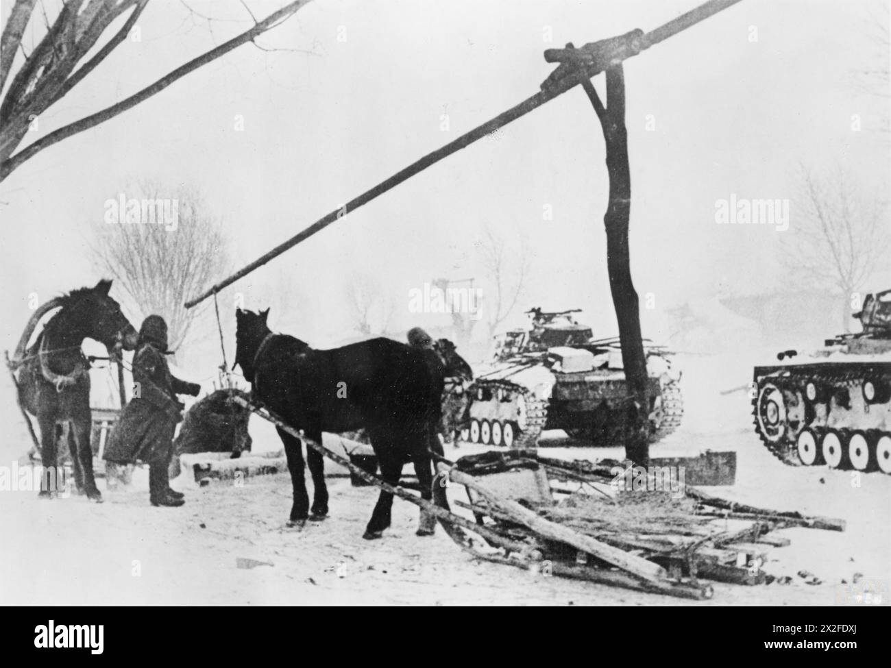 THE GERMAN ARMY ON THE EASTERN FRONT, 1941-1945 - German soldiers have to get water for cooking and washing from frozen springs. Panzer III tanks stand by in deep snow in an area east of Kursk, 1-10 March 1942 German Army Stock Photo