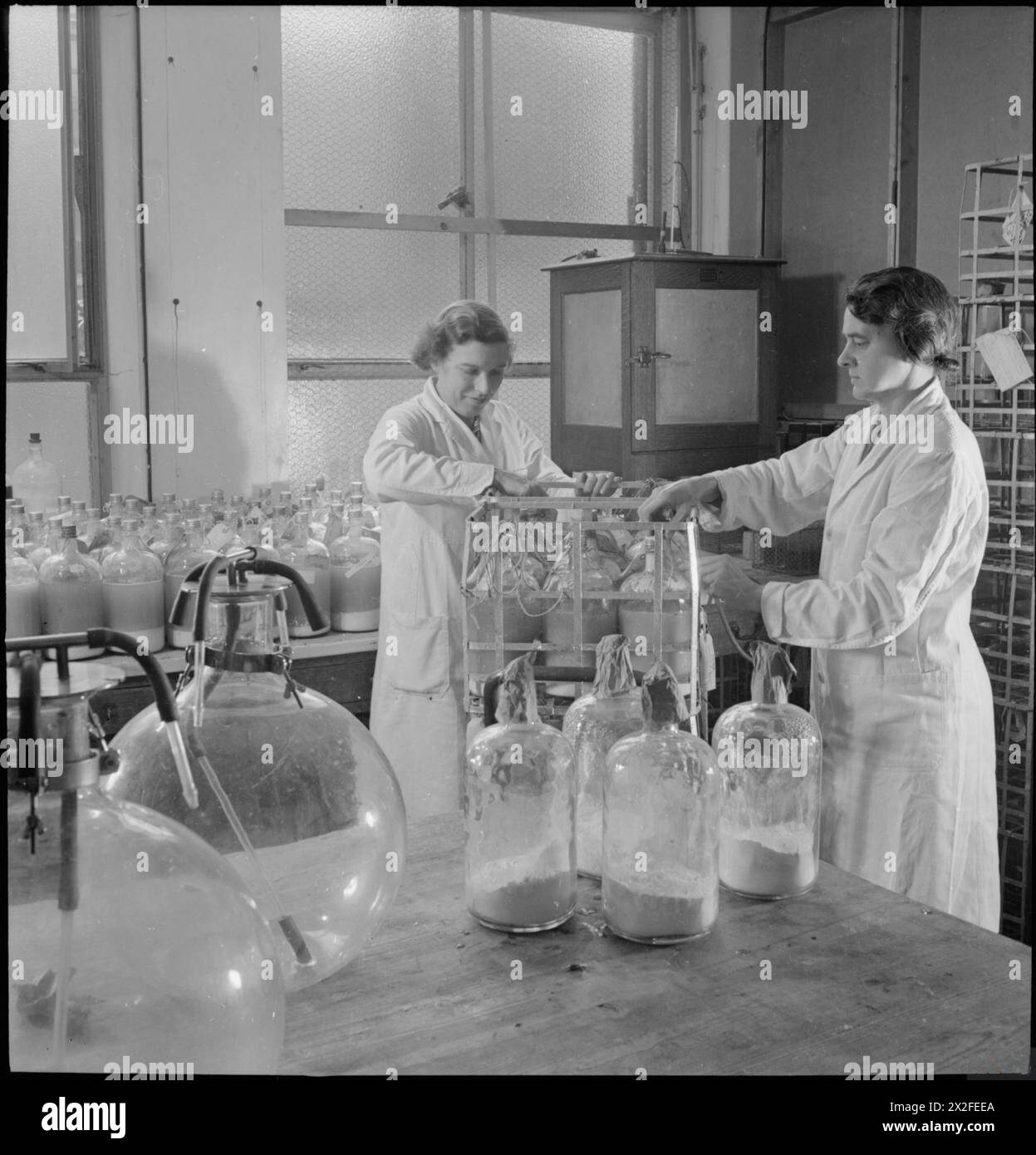 Lab Banks Two laboratory workers at Cambridge University unpack large bottles of ...