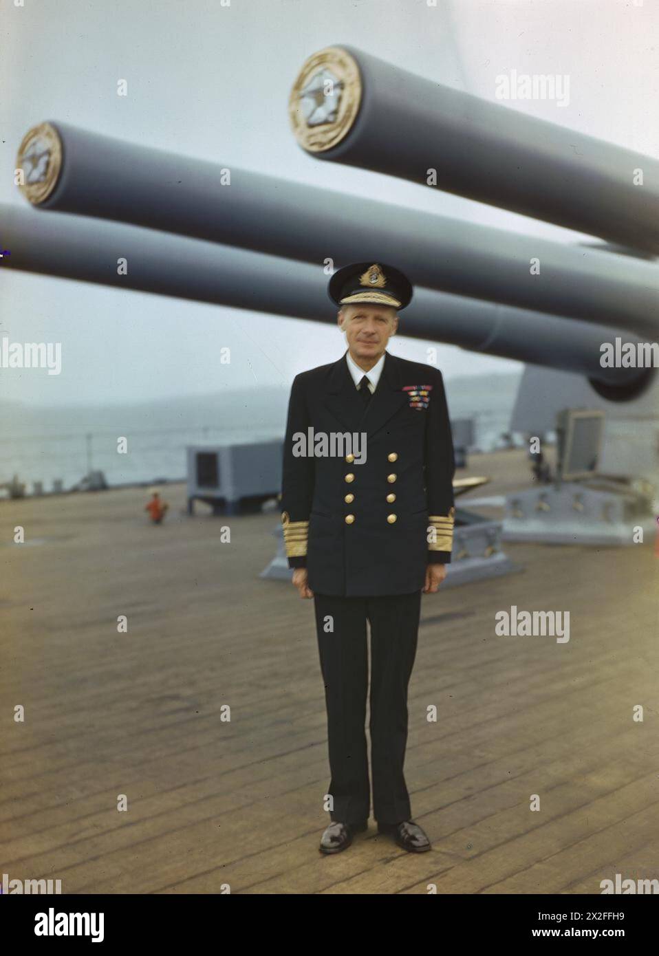 THE ROYAL NAVY DURING THE SECOND WORLD WAR: PERSONALITIES - Full length portrait of Admiral Sir Henry Ruthven Moore KCB, CVO, DSO, Commander in Chief Home Fleet, under the guns of his flagship HMS DUKE OF YORK at Scapa Flow Moore, Henry Ruthven, Royal Navy Stock Photo