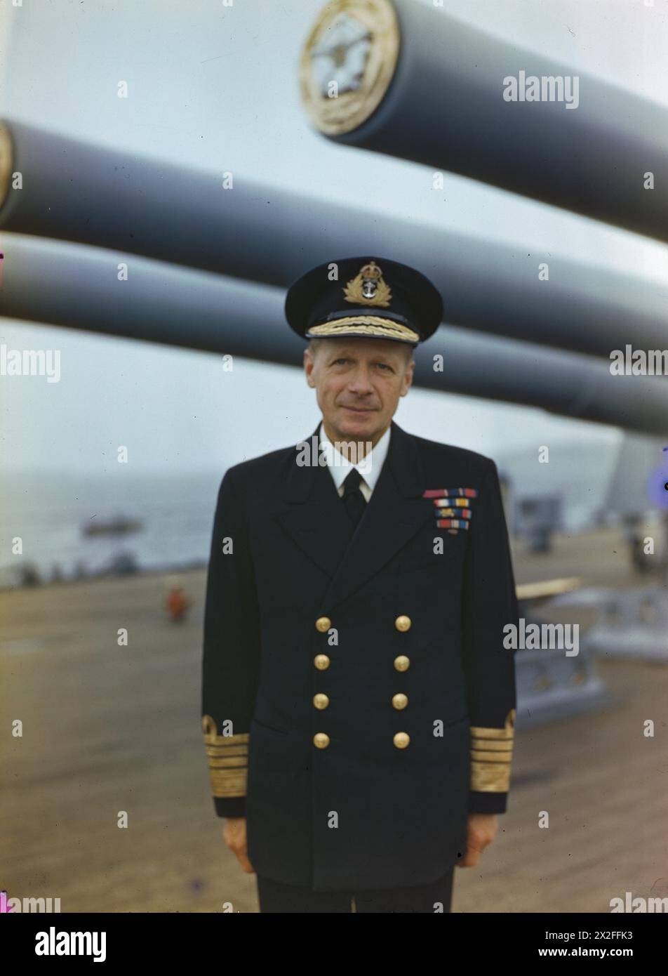 THE ROYAL NAVY DURING THE SECOND WORLD WAR: PERSONALITIES - Half length portrait of Admiral Sir Henry Ruthven Moore KCB, CVO, DSO, Commander in Chief Home Fleet, under the guns of his flagship HMS DUKE OF YORK at Scapa Flow Moore, Henry Ruthven, Royal Navy Stock Photo