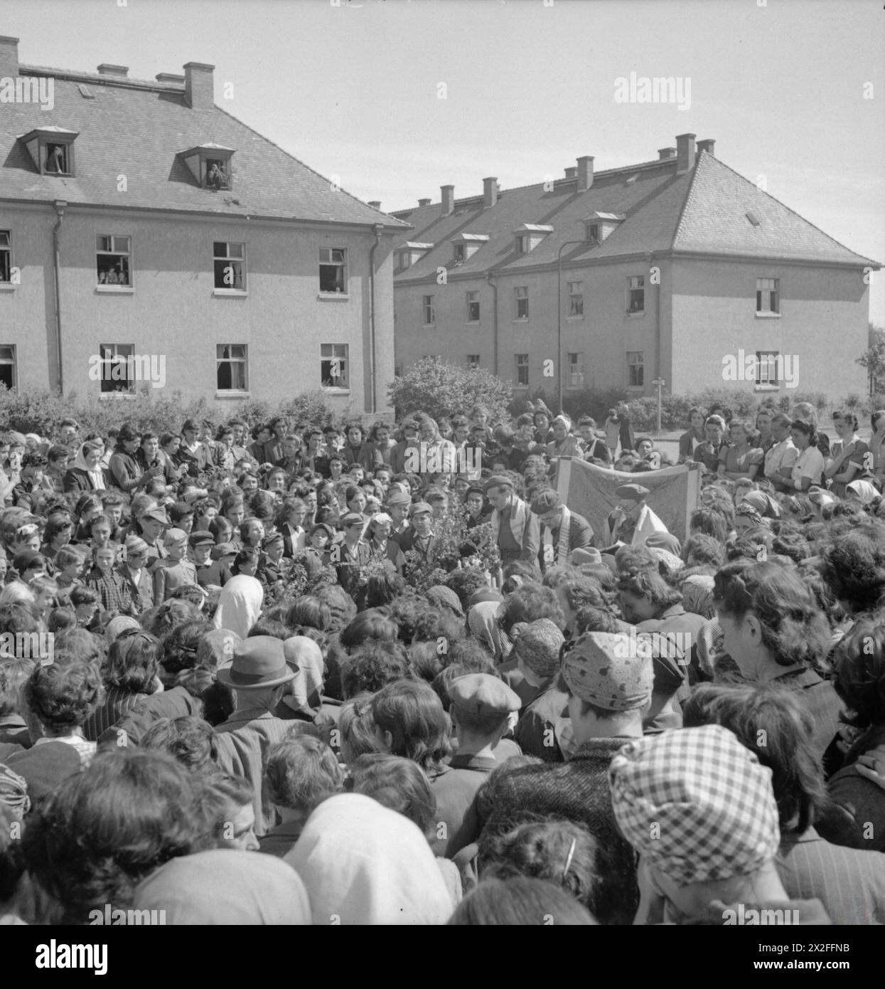 THE LIBERATION OF BERGEN-BELSEN CONCENTRATION CAMP, MAY 1945 - Jewish camp inmates hold an open air service to celebrate the Jewish Summer Festival of Thanksgiving. The service was led by Rev Leslie H Hardman, Senior Jewish Chaplain to the British 2nd Army, and former camp inmates, Rabbi H Helfgott of Jugoslovia and Rabbi B Goldfinger of Poland. Behind the open air altar internees hold up a tapestry originally owned by the Jewish community in Sicily, which was brought into the camp and hidden by internees until liberation British Army, Royal Army Chaplains' Department Stock Photo