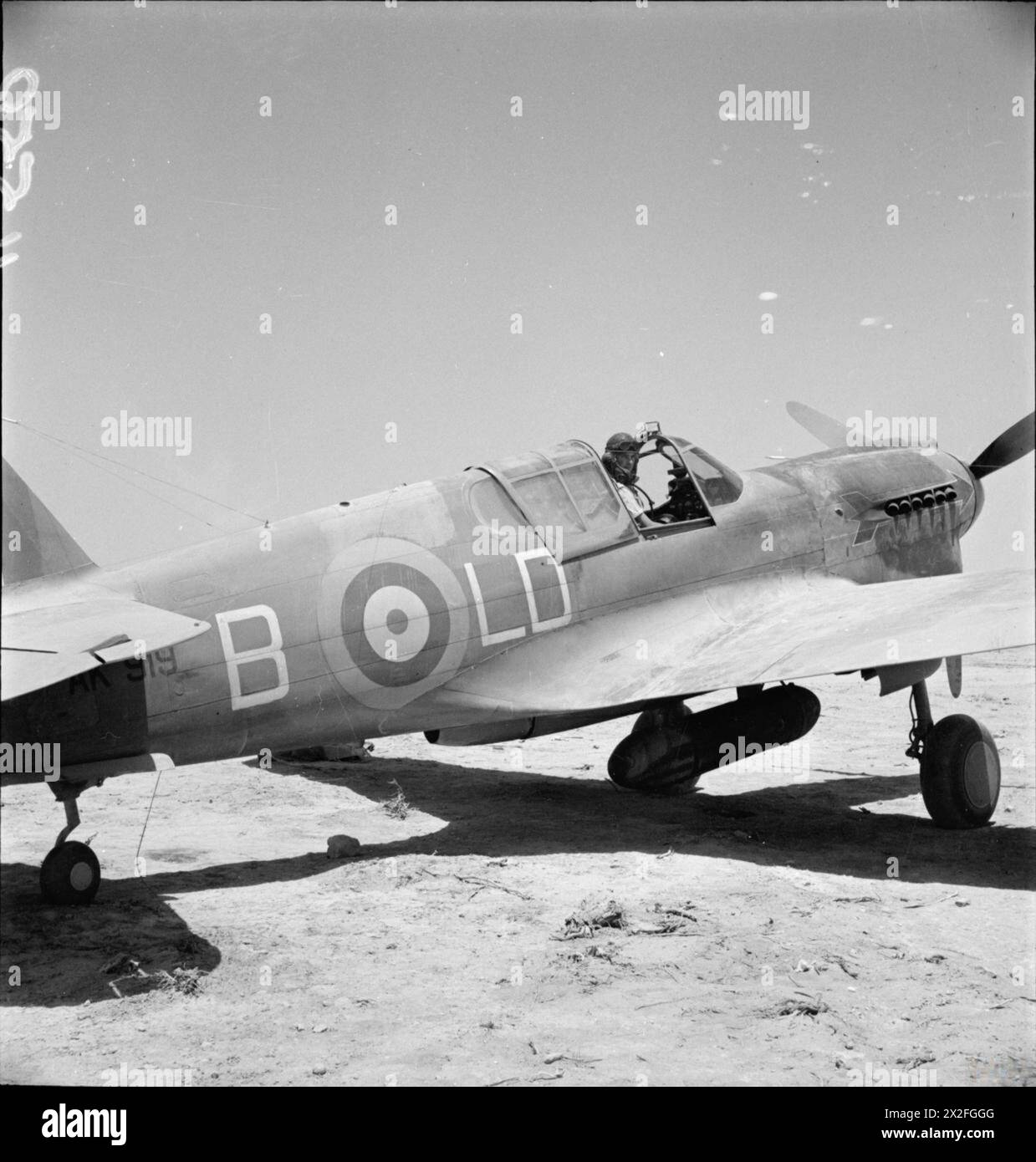 ROYAL AIR FORCE: OPERATIONS IN THE MIDDLE EAST AND NORTH AFRICA, 1940-1943. - Squadron Leader M T Judd, Officer Commanding No. 250 Squadron RAF, sitting in the cockpit of Curtiss Kittyhawk Mark I, AK919 'LD-B', at LG 91, Egypt. It was in this aircraft that Judd shot down a Junkers Ju 87 over LG 21 on 8 July 1942, and damaged another on 19 July. Note the red arrow unit marking over the exhaust stubs on the engine cowling Royal Air Force, Wing, 250 Stock Photo