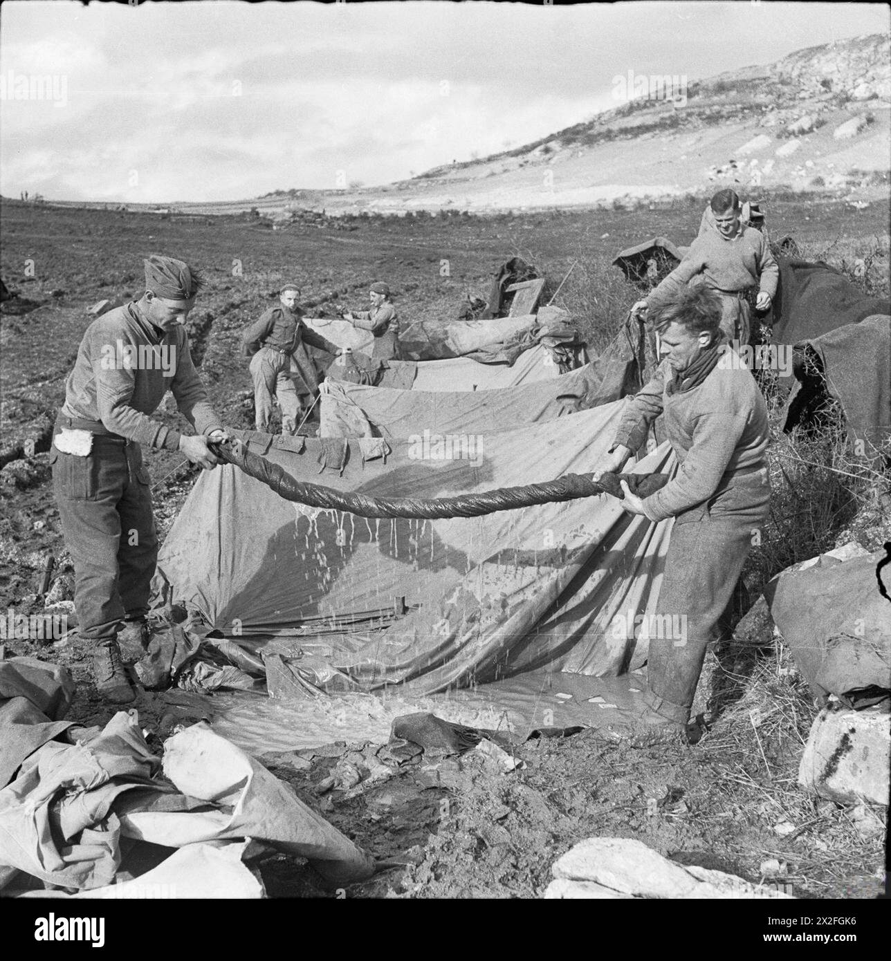 THE CAMPAIGN IN ITALY, SEPTEMBER-DECEMBER 1943: THE ALLIED ADVANCE TO THE GUSTAV LINE - Monte Camino November - December 1943: Two artillerymen (Sergeant J Hamilton and Gunner H Tennant) wringing water out of a blanket at their flooded bivouac on Monte Camino British Army, Royal Artillery Stock Photo