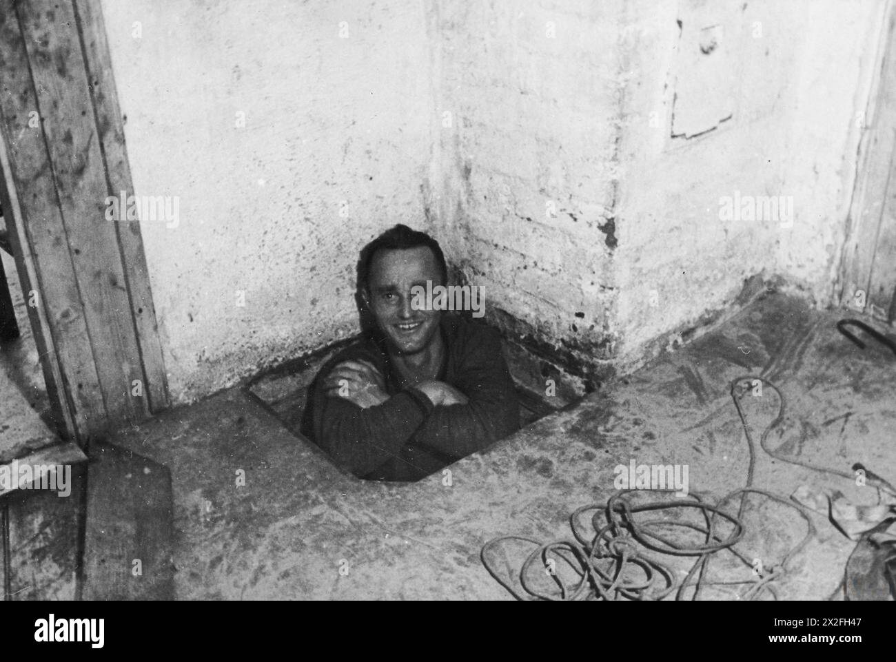 THE GREAT ESCAPE, MARCH 1944 - Corporal Karl Greise, one of the German guards known as 'Rubberneck', in the entrance to the escape tunnel 'Tom' at Stalag Luft III, Sagan. Photograph probably taken in September 1943 German Air Force, Greise, Karl Stock Photo