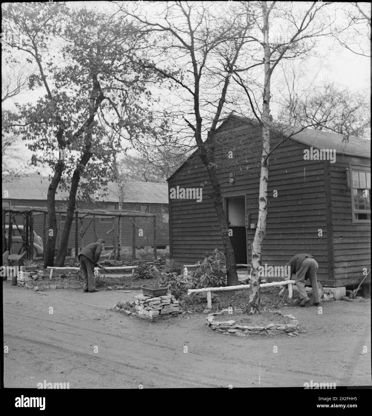 WAKEFIELD TRAINING PRISON AND CAMP: EVERYDAY LIFE IN A BRITISH PRISON, WAKEFIELD, YORKSHIRE, ENGLAND, 1944 - In their spare time, inmates at Wakefield Training Prison tend the gardens they have created outside their huts Stock Photo