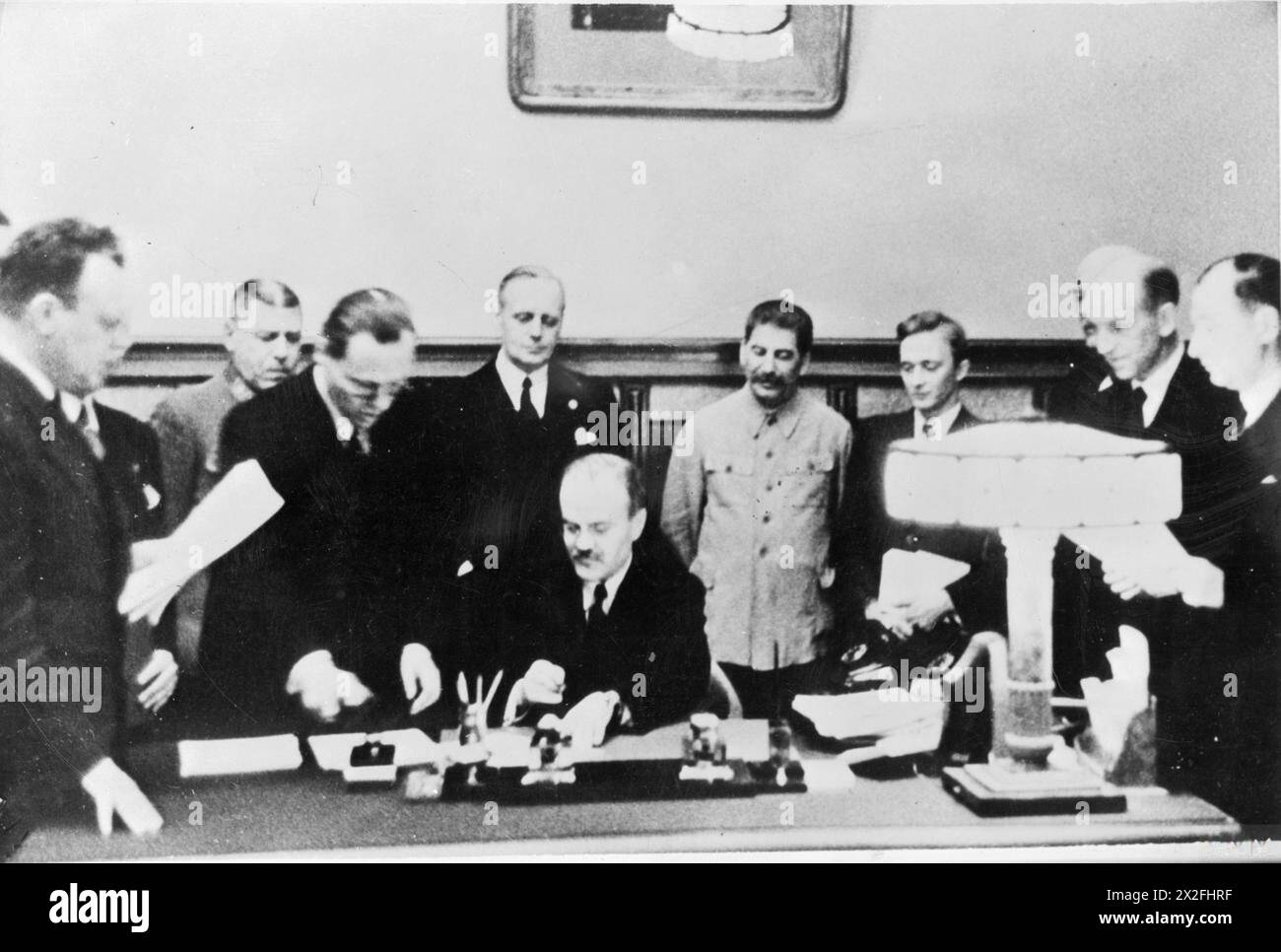 THE NAZI-SOVIET NON-AGGRESSION PACT (THE RIBBENTROP-MOLOTOV PACT) - The Soviet Minister for Foreign Affairs, Vyacheslav Molotov, signs the Nazi-Soviet Non-Aggression Pact (also known as the Molotov-Ribbentrop Pact) in the presence of the German Foreign Minister, Joachim von Ribbentrop and the Soviet leader Josef Stalin (both standing immediately behind), in Moscow, 28 September 1939 Molotov, Vyacheslav Mikhailovich, Stalin, Joseph, Ribbentrop, Joachim von, Shaposhnikov, Boris Mikhailovitch Stock Photo