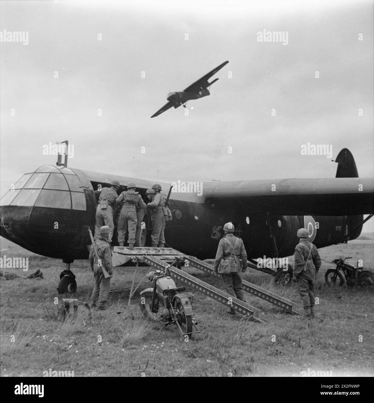 THE BRITISH ARMY IN THE UNITED KINGDOM 1939-45 - Airborne troops unloading motorcycles from a Horsa glider at RAF Netheravon, December 1942. Another glider can be seen overhead Stock Photo