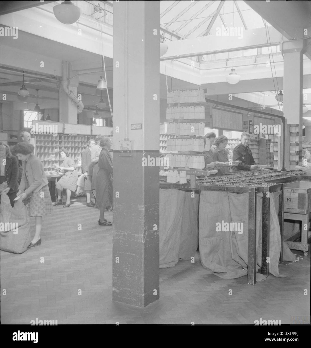 A PICTURE OF A SOUTHERN TOWN: LIFE IN WARTIME READING, BERKSHIRE, ENGLAND, UK, 1945 - A general view of mail sorting in progress at Reading GPO (General Post Office). According to the original caption '654,000 letters and 18,000 parcels are posted per week, 700,000 letters and 20,000 parcels delivered per week; 1,313,000 letters and 101,475 parcels are passed through to other offices' Stock Photo