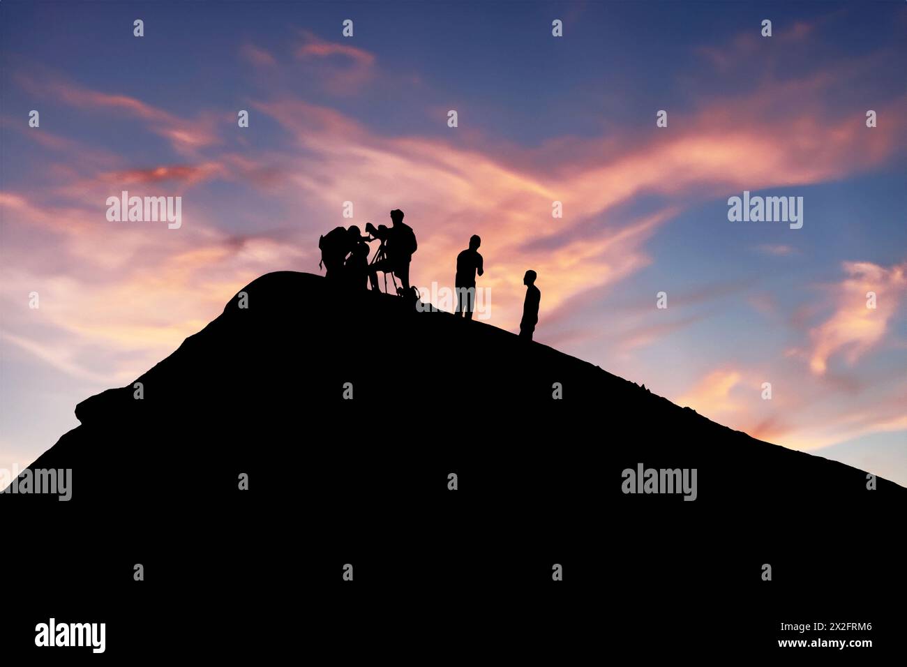 Silhouetted team conducting volcano research during picturesque sunset backdrop Stock Photo