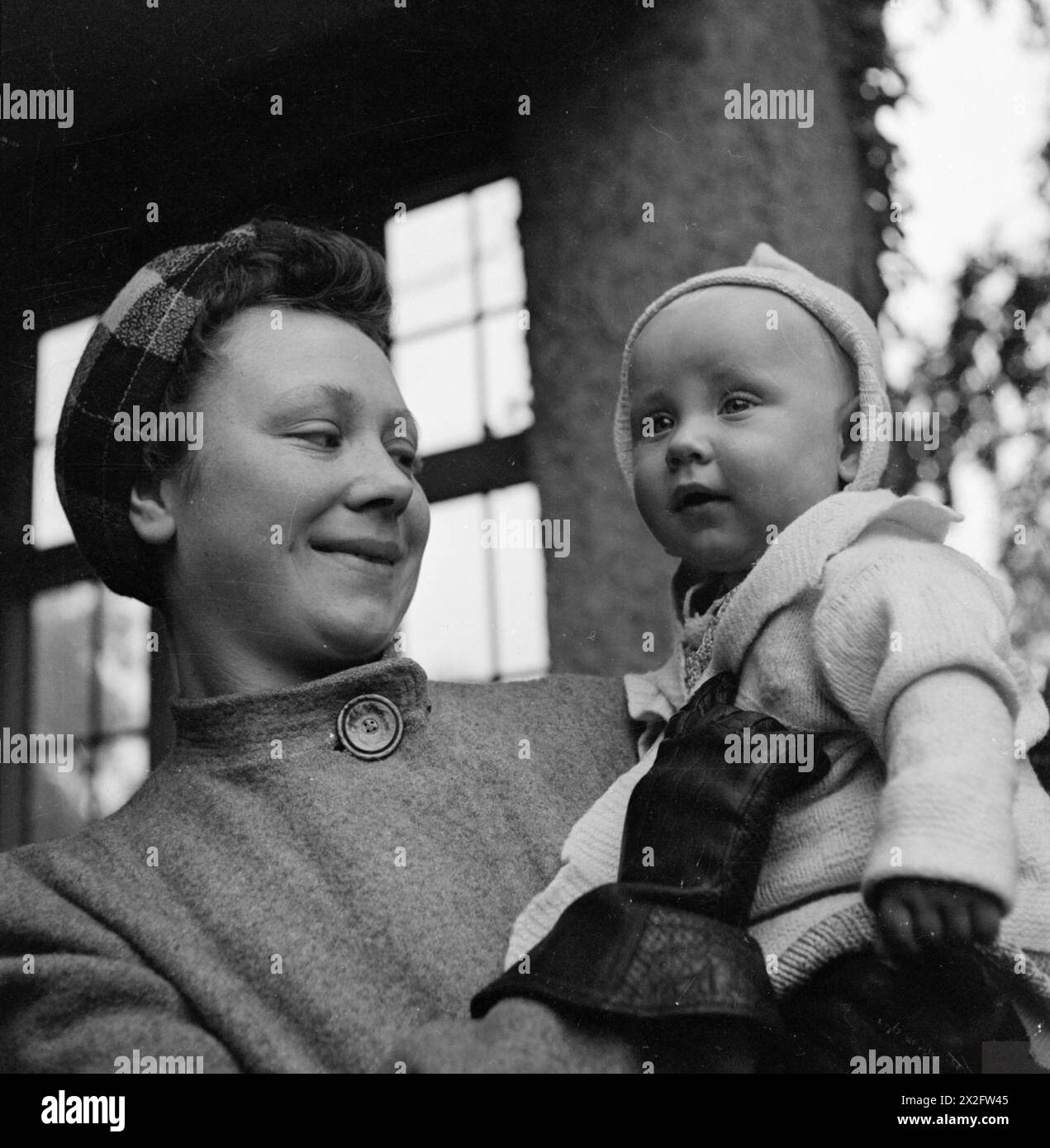 NURSERY FOR WORKING MOTHERS: THE WORK OF FLINT GREEN ROAD NURSERY, BIRMINGHAM, 1942 - 8 month old Keith arrives at the nursery for the day at 7am. His mother gives him a hug goodbye before she leaves for a day's work Stock Photo