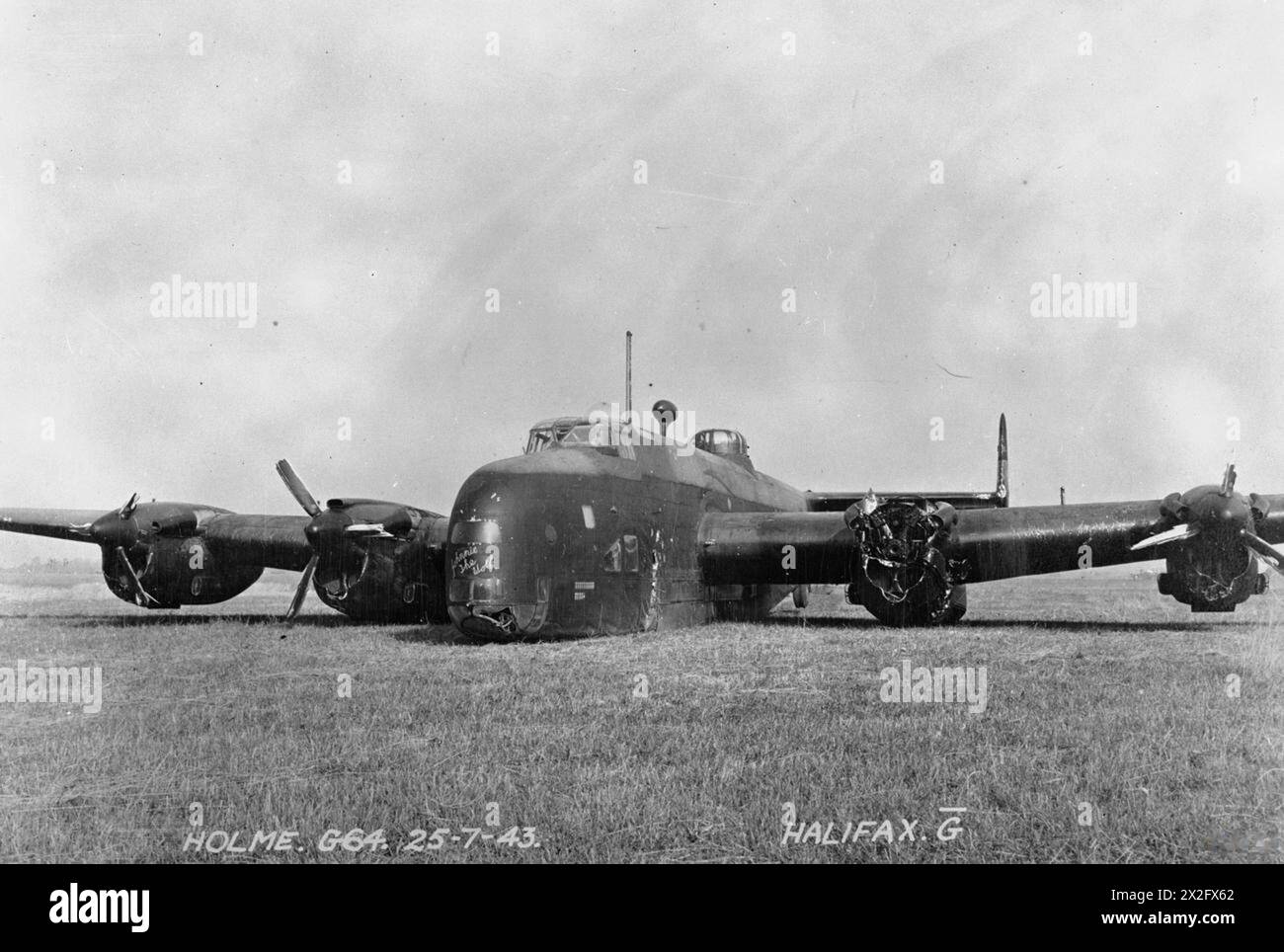 ROYAL AIR FORCE BOMBER COMMAND, 1942-1945. - Handley Page Halifax B Mark II Series I (Special), DK148 'MP-G' 'Johnnie the Wolf', of No. 76 Squadron RAF rests at Holme-on-Spalding Moor, Yorkshire, after crash-landing on return from an operation to Essen on the night of 25/26 July 1943. The propeller from the damaged port-inner engine flew off shortly after the bombing run, tearing a large hole in the fuselage. The mid-upper gunner immediately baled out, but the pilot, Flight Lieutenant C M Shannon, regained control of the aircraft and managed to bring the rest of the crew back to Holme, althoug Stock Photo
