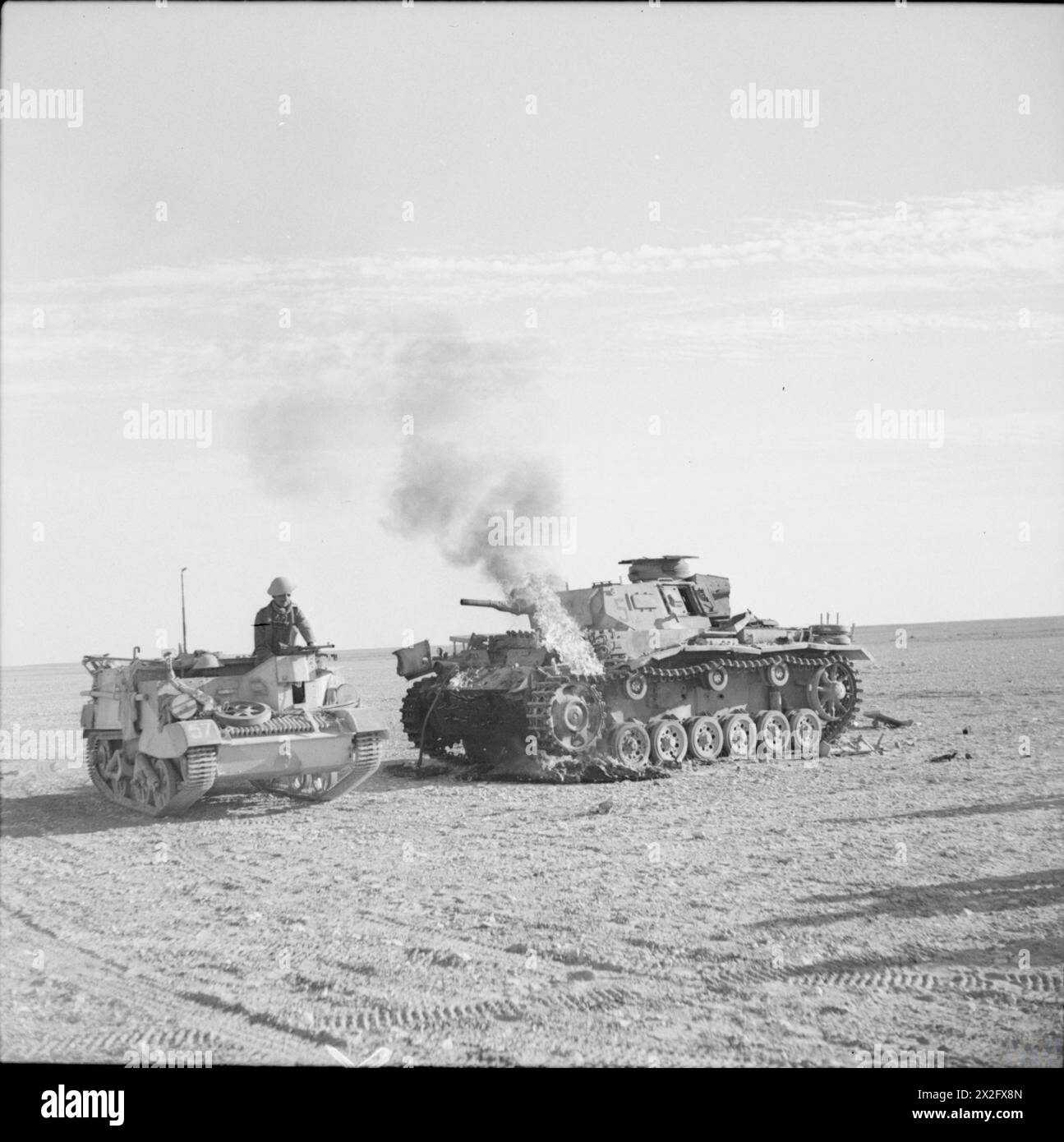 A British Bren gun carrier passes a burning German PzKpfw III tank in ...